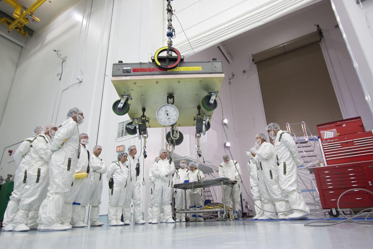CAPE CANAVERAL, Fla. -- At Astrotech Space Operation's payload processing facility in Titusville, Fla., Lockheed Martin technicians review procedures for weighing one of NASA's twin Gravity Recovery and Interior Laboratory lunar spacecraft before the spacecraft are stacked in their launch configuration in preparation for transport to the launch pad. GRAIL will fly in tandem orbits around the moon for several months to measure its gravity field. GRAIL's primary science objectives are to determine the structure of the lunar interior, from crust to core, and to advance understanding of the thermal evolution of the moon. Launch aboard a United Launch Alliance Delta II rocket from Space Launch Complex 17B on Cape Canaveral Air Force Station is scheduled for Sept. 8. For more information, visit http://www.nasa.gov/grail. Photo credit: NASA/Jim Grossmann