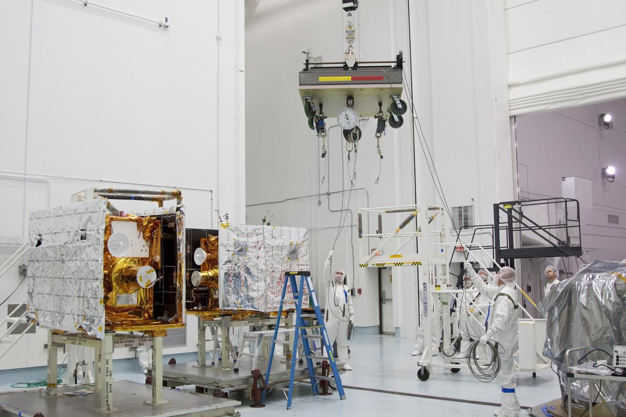 CAPE CANAVERAL, Fla. -- At Astrotech Space Operation's payload processing facility in Titusville, Fla., Lockheed Martin technicians move a lifting device toward NASA's Gravity Recovery and Interior Laboratory-B (GRAIL-B) lunar probe. At left is GRAIL-A.  After the twin GRAIL spacecraft are attached to the spacecraft adapter ring in their side-by-side launch configuration, they will be transported to the launch pad.    GRAIL will fly in tandem orbits around the moon for several months to measure its gravity field. GRAIL's primary science objectives are to determine the structure of the lunar interior, from crust to core, and to advance understanding of the thermal evolution of the moon.  Launch aboard a United Launch Alliance Delta II rocket from Space Launch Complex 17B on Cape Canaveral Air Force Station is scheduled for Sept. 8.  For more information, visit http://www.nasa.gov/grail. Photo credit: NASA/Jim Grossmann