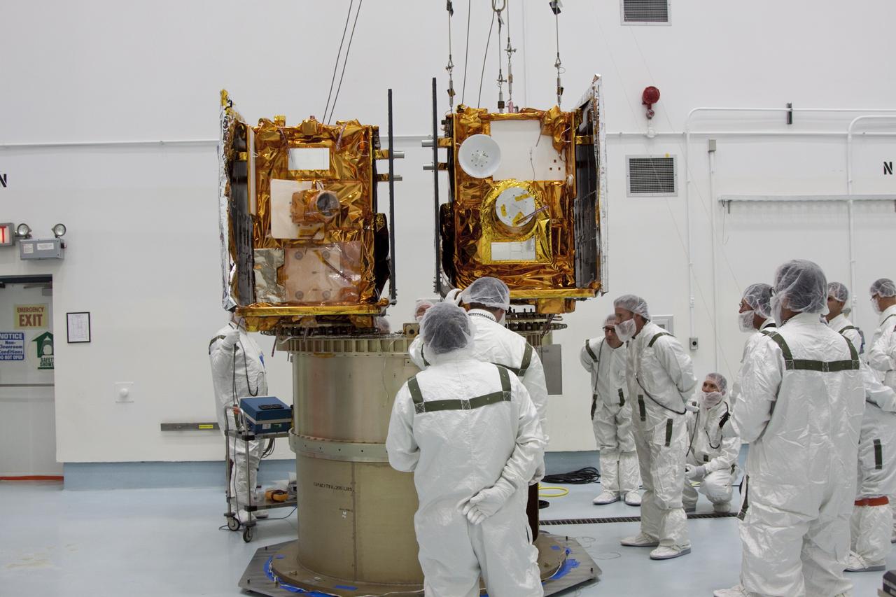 CAPE CANAVERAL, Fla. -- At Astrotech Space Operation's payload processing facility in Titusville, Fla., Lockheed Martin technicians monitor the placement of NASA's Gravity Recovery and Interior Laboratory-A (GRAIL-A) lunar probe on the spacecraft adapter ring. GRAIL-B is already secured to the ring, at left.  After the twin GRAIL spacecraft are attached to the adapter ring in their side-by-side launch configuration, they will be transported to the launch pad.    GRAIL will fly in tandem orbits around the moon for several months to measure its gravity field. GRAIL's primary science objectives are to determine the structure of the lunar interior, from crust to core, and to advance understanding of the thermal evolution of the moon.  Launch aboard a United Launch Alliance Delta II rocket from Space Launch Complex 17B on Cape Canaveral Air Force Station is scheduled for Sept. 8.  For more information, visit http://www.nasa.gov/grail. Photo credit: NASA/Jim Grossmann