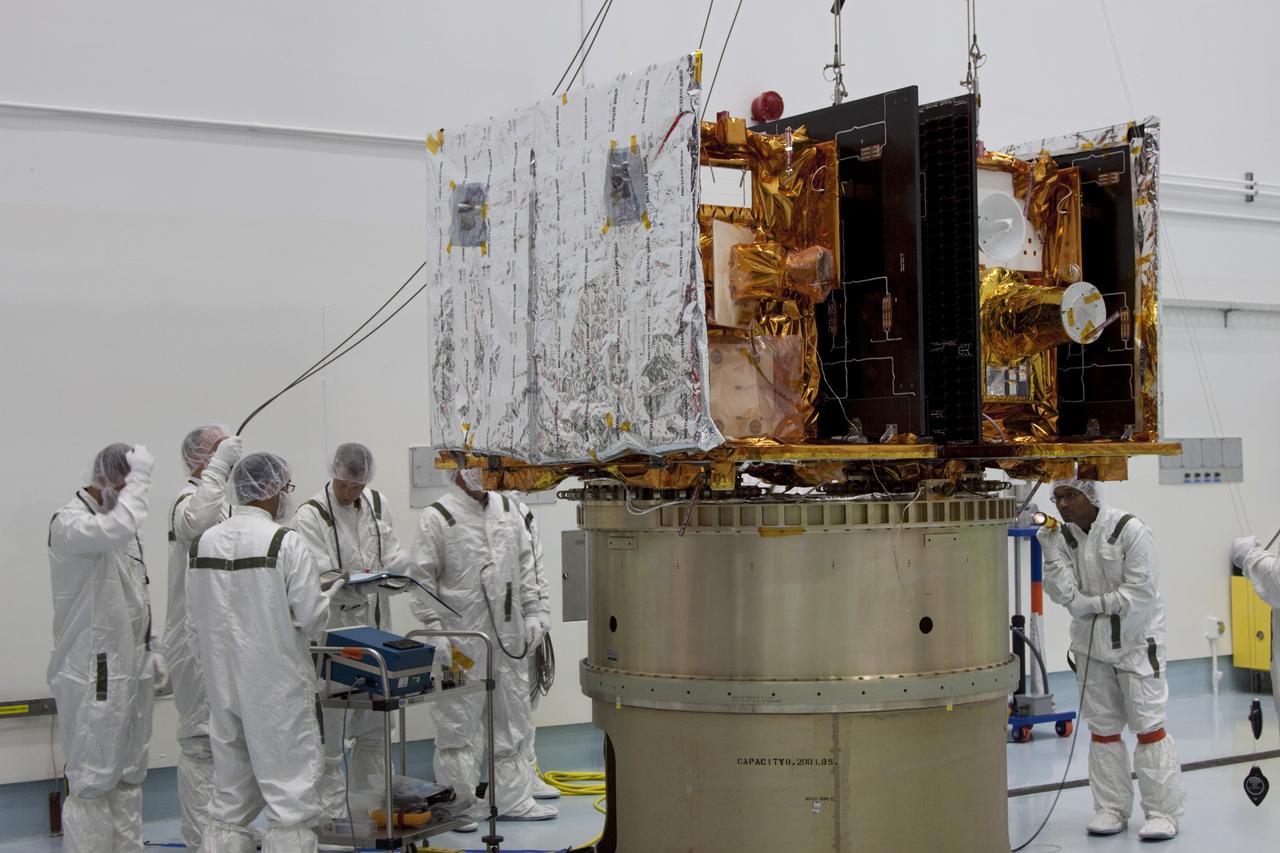 CAPE CANAVERAL, Fla. -- At Astrotech Space Operation's payload processing facility in Titusville, Fla., Lockheed Martin technicians verify that NASA's Gravity Recovery and Interior Laboratory-A (GRAIL-A) lunar probe is in position and ready to be secured to the spacecraft adapter ring. GRAIL-B is secured to the ring, at left.  After the twin GRAIL spacecraft are attached to the adapter ring in their side-by-side launch configuration, they will be transported to the launch pad.    GRAIL will fly in tandem orbits around the moon for several months to measure its gravity field. GRAIL's primary science objectives are to determine the structure of the lunar interior, from crust to core, and to advance understanding of the thermal evolution of the moon.  Launch aboard a United Launch Alliance Delta II rocket from Space Launch Complex 17B on Cape Canaveral Air Force Station is scheduled for Sept. 8.  For more information, visit http://www.nasa.gov/grail. Photo credit: NASA/Jim Grossmann