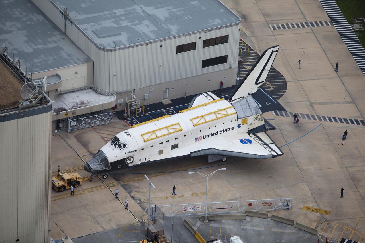 CAPE CANAVERAL, Fla. -- At NASA's Kennedy Space Center in Florida, space shuttle Endeavour backs out of Orbiter Processing Facility-1 (OPF-1).  Endeavour is switching places with shuttle Discovery which temporarily has been housed in the Vehicle Assembly Building (VAB).  Both shuttles will stop briefly outside OPF-3 for a "nose-to-nose" photo opportunity. Discovery then will be rolled into OPF-1 and Endeavour into the VAB.    The image was taken from the top of the VAB.  In OPF-1, Discovery will undergo further preparations for public display at the Smithsonian's National Air and Space Museum Steven F. Udvar-Hazy Center in Virginia. Endeavour will be stored in the VAB until October when it will be moved into OPF-2 for further work to get it ready for public display at the California Science Center in Los Angeles.  For more information, visit http://www.nasa.gov/shuttle. Photo credit: NASA/Frankie Martin