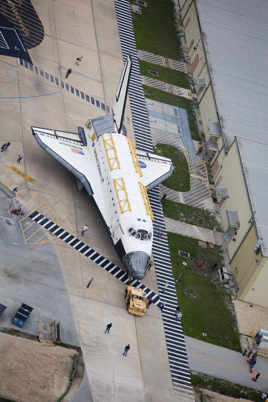 CAPE CANAVERAL, Fla. -- At NASA's Kennedy Space Center in Florida, space shuttle Discovery leaves the Vehicle Assembly Building (VAB) behind for a rendezvous with shuttle Endeavour.  Discovery is switching places with Endeavour which has been undergoing decommissioning in Orbiter Processing Facility-1 (OPF-1).  Both shuttles will stop briefly outside OPF-3 for a "nose-to-nose" photo opportunity. Discovery then will be rolled into OPF-1 and Endeavour into the VAB.    The image was taken from the top of the VAB.  In OPF-1, Discovery will undergo further preparations for public display at the Smithsonian's National Air and Space Museum Steven F. Udvar-Hazy Center in Virginia. Endeavour will be stored in the VAB until October when it will be moved into OPF-2 for further work to get it ready for public display at the California Science Center in Los Angeles.  For more information, visit http://www.nasa.gov/shuttle. Photo credit: NASA/Frankie Martin