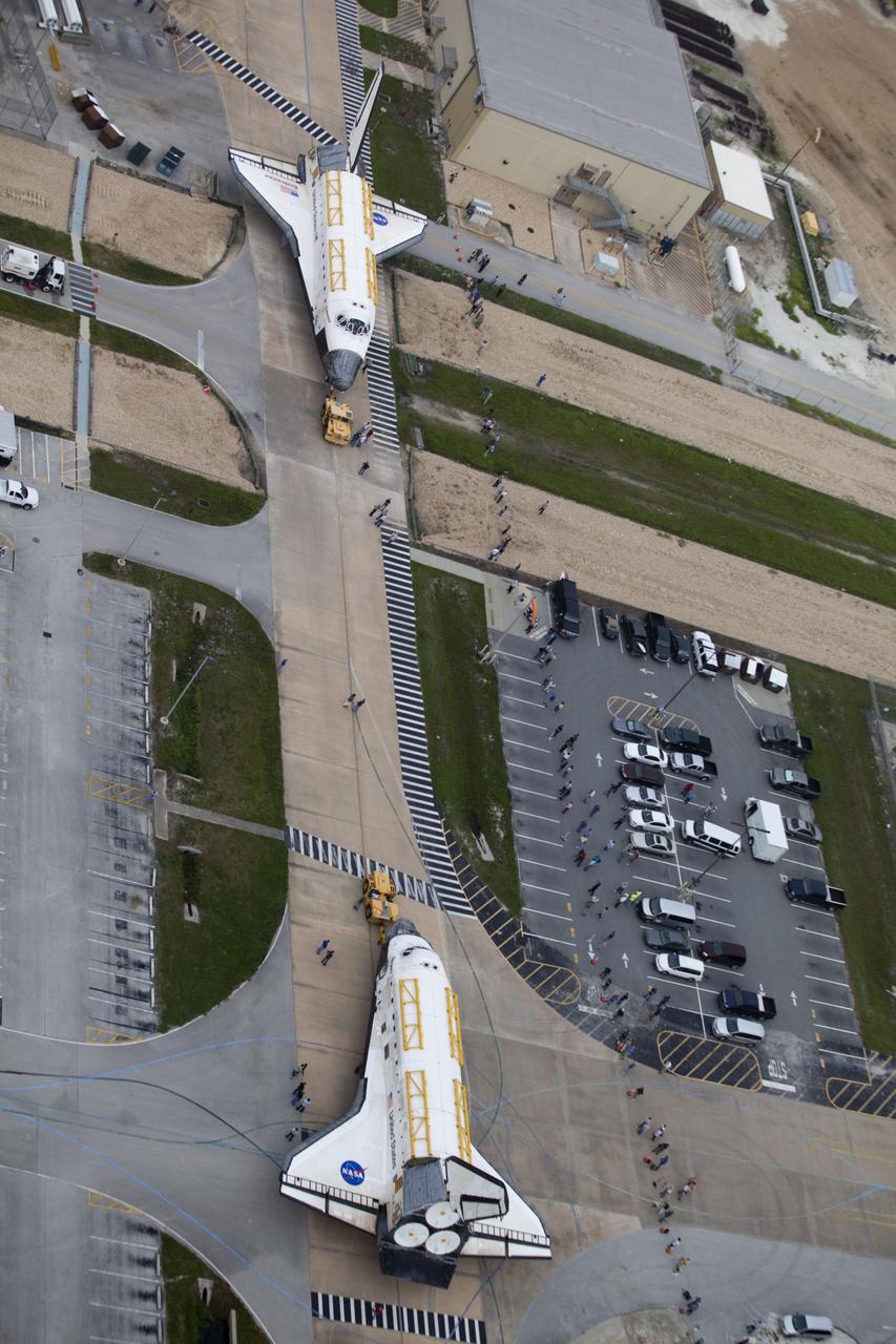 CAPE CANAVERAL, Fla. -- At NASA's Kennedy Space Center in Florida, space shuttle Discovery, at right, approaches shuttle Endeavour outside Orbiter Processing Facility-3 (OPF-3). Discovery, which temporarily was being stored in the Vehicle Assembly Building (VAB), is switching places with Endeavour, which has been undergoing decommissioning in Orbiter Processing Facility-1 (OPF-1). Both shuttles will stop briefly outside OPF-3 for a "nose-to-nose" photo opportunity. Discovery then will be rolled into OPF-1 and Endeavour into the VAB. The image was taken from the top of the VAB. In OPF-1, Discovery will undergo further preparations for public display at the Smithsonian's National Air and Space Museum Steven F. Udvar-Hazy Center in Virginia. Endeavour will be stored in the VAB until October when it will be moved into OPF-2 for further work to get it ready for public display at the California Science Center in Los Angeles. For more information, visit http://www.nasa.gov/shuttle. Photo credit: NASA/Frankie Martin