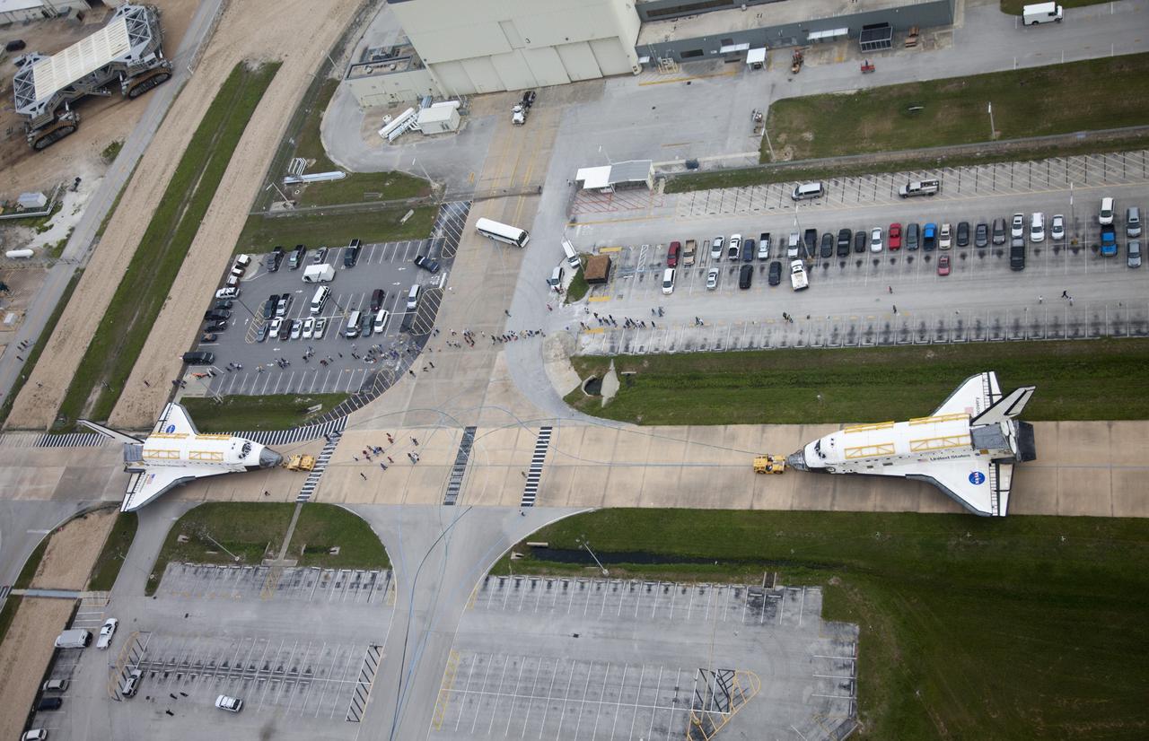 CAPE CANAVERAL, Fla. -- At NASA's Kennedy Space Center in Florida, space shuttle Discovery, at right, approaches shuttle Endeavour outside Orbiter Processing Facility-3 (OPF-3). Discovery, which temporarily was being stored in the Vehicle Assembly Building (VAB), is switching places with Endeavour, which has been undergoing decommissioning in Orbiter Processing Facility-1 (OPF-1). Both shuttles will stop briefly outside OPF-3 for a "nose-to-nose" photo opportunity. Discovery then will be rolled into OPF-1 and Endeavour into the VAB. The image was taken from the top of the VAB. In OPF-1, Discovery will undergo further preparations for public display at the Smithsonian's National Air and Space Museum Steven F. Udvar-Hazy Center in Virginia. Endeavour will be stored in the VAB until October when it will be moved into OPF-2 for further work to get it ready for public display at the California Science Center in Los Angeles. For more information, visit http://www.nasa.gov/shuttle. Photo credit: NASA/Frankie Martin