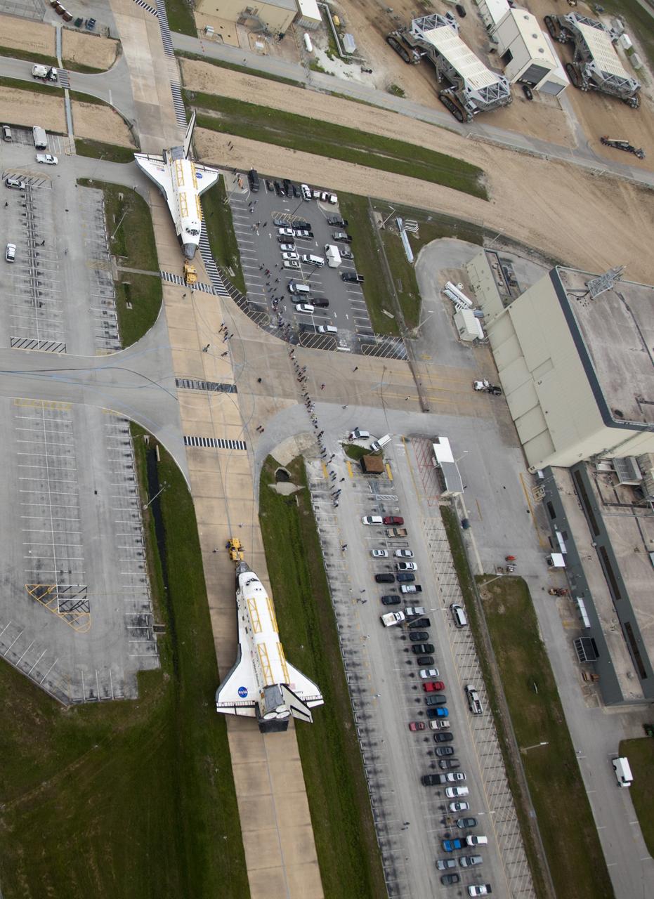 CAPE CANAVERAL, Fla. -- At NASA's Kennedy Space Center in Florida, space shuttle Discovery, at right, approaches shuttle Endeavour outside Orbiter Processing Facility-3 (OPF-3). Discovery, which temporarily was being stored in the Vehicle Assembly Building (VAB), is switching places with Endeavour, which has been undergoing decommissioning in Orbiter Processing Facility-1 (OPF-1). Both shuttles will stop briefly outside OPF-3 for a "nose-to-nose" photo opportunity. Discovery then will be rolled into OPF-1 and Endeavour into the VAB. The image was taken from the top of the VAB. In OPF-1, Discovery will undergo further preparations for public display at the Smithsonian's National Air and Space Museum Steven F. Udvar-Hazy Center in Virginia. Endeavour will be stored in the VAB until October when it will be moved into OPF-2 for further work to get it ready for public display at the California Science Center in Los Angeles. For more information, visit http://www.nasa.gov/shuttle. Photo credit: NASA/Frankie Martin