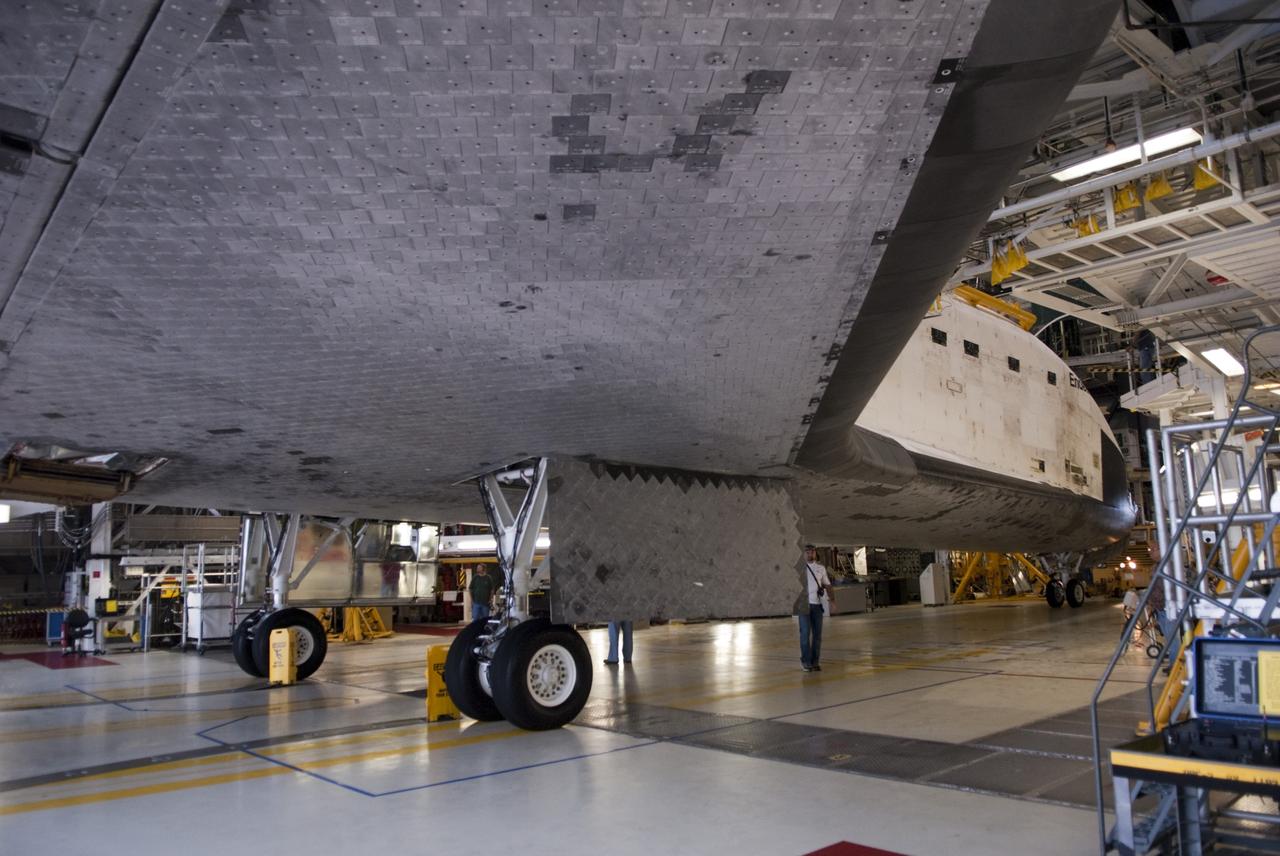 CAPE CANAVERAL, Fla. -- At NASA's Kennedy Space Center in Florida, a spacecraft technician, standing beneath the thermal protection system tile on the underbelly of space shuttle Endeavour, prepares to support the spacecraft's move from Orbiter Processing Facility-1 (OPF-1) to the Vehicle Assembly Building (VAB).  Endeavour is switching places with shuttle Discovery which temporarily has been stored in the VAB.  Both shuttles will stop briefly outside OPF-3 for a "nose-to-nose" photo opportunity. Discovery then will be rolled into OPF-1 and Endeavour into the VAB.    In OPF-1, Discovery will undergo further preparations for public display at the Smithsonian's National Air and Space Museum Steven F. Udvar-Hazy Center in Virginia. Endeavour will be stored in the VAB until October when it will be moved into OPF-2 for further work to get it ready for public display at the California Science Center in Los Angeles.  For more information, visit http://www.nasa.gov/shuttle. Photo credit: NASA/Jim Grossmann