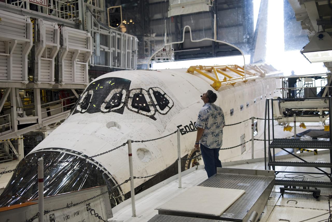 CAPE CANAVERAL, Fla. -- At NASA's Kennedy Space Center in Florida, a spacecraft technician, standing on a work platform next to space shuttle Endeavour, monitors the shuttle as it rolls toward the open door of Orbiter Processing Facility-1 (OPF-1), beginning its move to the Vehicle Assembly Building (VAB). Endeavour is switching places with shuttle Discovery which temporarily has been stored in the VAB. Both shuttles will stop briefly outside OPF-3 for a "nose-to-nose" photo opportunity. Discovery then will be rolled into OPF-1 and Endeavour into the VAB. In OPF-1, Discovery will undergo further preparations for public display at the Smithsonian's National Air and Space Museum Steven F. Udvar-Hazy Center in Virginia. Endeavour will be stored in the VAB until October when it will be moved into OPF-2 for further work to get it ready for public display at the California Science Center in Los Angeles. For more information, visit http://www.nasa.gov/shuttle. Photo credit: NASA/Jim Grossmann