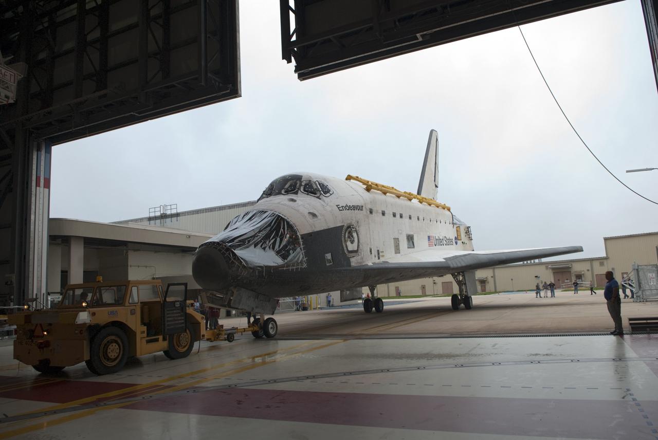 CAPE CANAVERAL, Fla. -- At NASA's Kennedy Space Center in Florida, space shuttle Endeavour, its nose encased in protective plastic where its forward reaction control system (FRCS) once resided, backs out of Orbiter Processing Facility-1 (OPF-1) for its move to the Vehicle Assembly Building (VAB). Endeavour is switching places with shuttle Discovery which temporarily has been stored in the VAB. Both shuttles will stop briefly outside OPF-3 for a "nose-to-nose" photo opportunity. Discovery then will be rolled into OPF-1 and Endeavour into the VAB. In OPF-1, Discovery will undergo further preparations for public display at the Smithsonian's National Air and Space Museum Steven F. Udvar-Hazy Center in Virginia. Endeavour will be stored in the VAB until October when it will be moved into OPF-2 for further work to get it ready for public display at the California Science Center in Los Angeles. For more information, visit http://www.nasa.gov/shuttle. Photo credit: NASA/Jim Grossmann