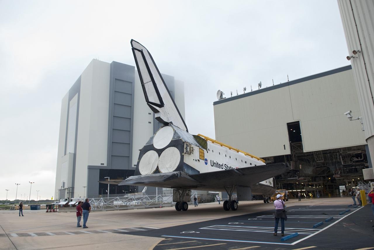 CAPE CANAVERAL, Fla. -- At NASA's Kennedy Space Center in Florida, space shuttle Endeavour backs out of Orbiter Processing Facility-1 (OPF-1) for a short jaunt to the Vehicle Assembly Building (VAB), in the background.  Endeavour is switching places with shuttle Discovery which temporarily has been stored in the VAB.  Both shuttles will stop briefly outside OPF-3 for a "nose-to-nose" photo opportunity. Discovery then will be rolled into OPF-1 and Endeavour into the VAB.    In OPF-1, Discovery will undergo further preparations for public display at the Smithsonian's National Air and Space Museum Steven F. Udvar-Hazy Center in Virginia. Endeavour will be stored in the VAB until October when it will be moved into OPF-2 for further work to get it ready for public display at the California Science Center in Los Angeles.  For more information, visit http://www.nasa.gov/shuttle. Photo credit: NASA/Jim Grossmann