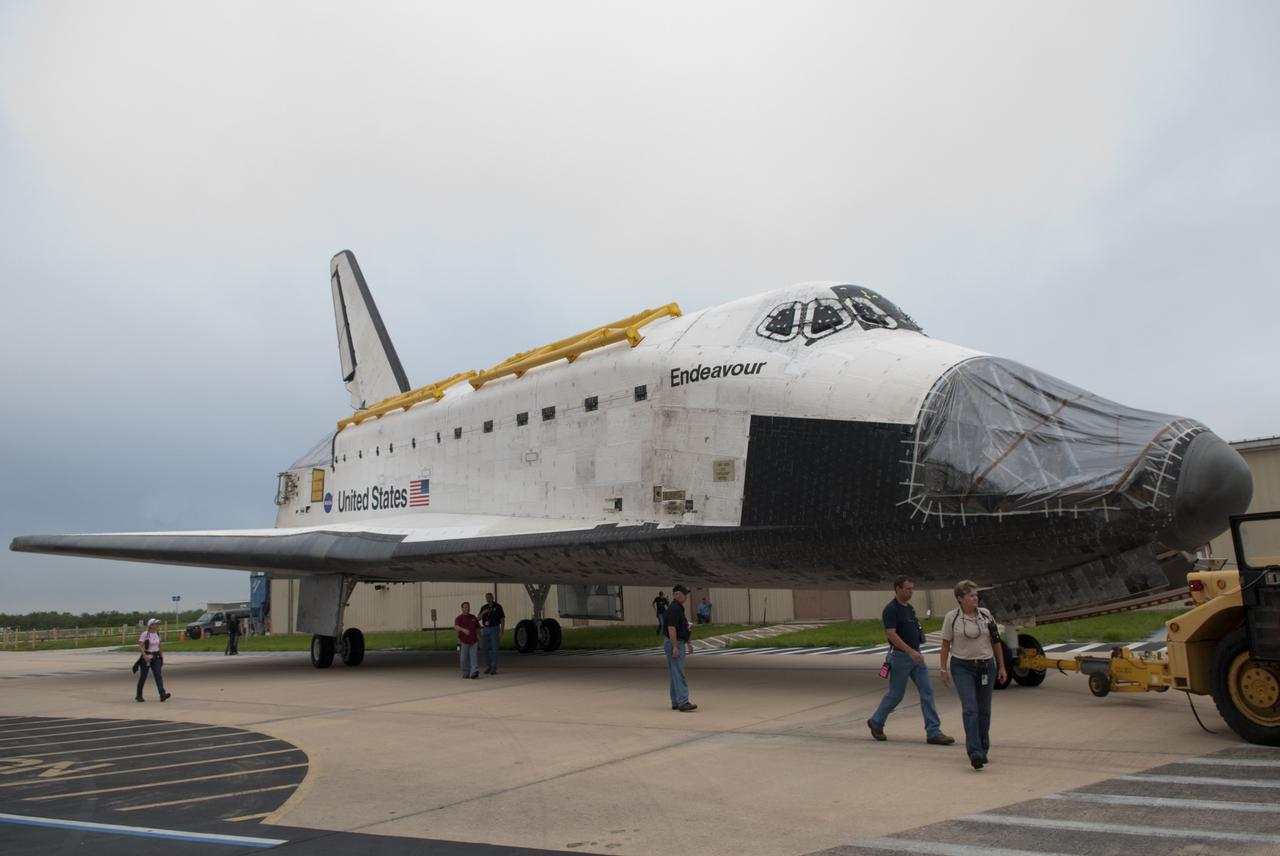 CAPE CANAVERAL, Fla. -- At NASA's Kennedy Space Center in Florida, United Space Alliance employees accompany space shuttle Endeavour as it is towed from Orbiter Processing Facility-1 (OPF-1) to the Vehicle Assembly Building (VAB).  Endeavour is switching places with shuttle Discovery which temporarily has been stored in the VAB.  Both shuttles will stop briefly outside OPF-3 for a "nose-to-nose" photo opportunity. Discovery then will be rolled into OPF-1 and Endeavour into the VAB.    In OPF-1, Discovery will undergo further preparations for public display at the Smithsonian's National Air and Space Museum Steven F. Udvar-Hazy Center in Virginia. Endeavour will be stored in the VAB until October when it will be moved into OPF-2 for further work to get it ready for public display at the California Science Center in Los Angeles.  For more information, visit http://www.nasa.gov/shuttle. Photo credit: NASA/Jim Grossmann