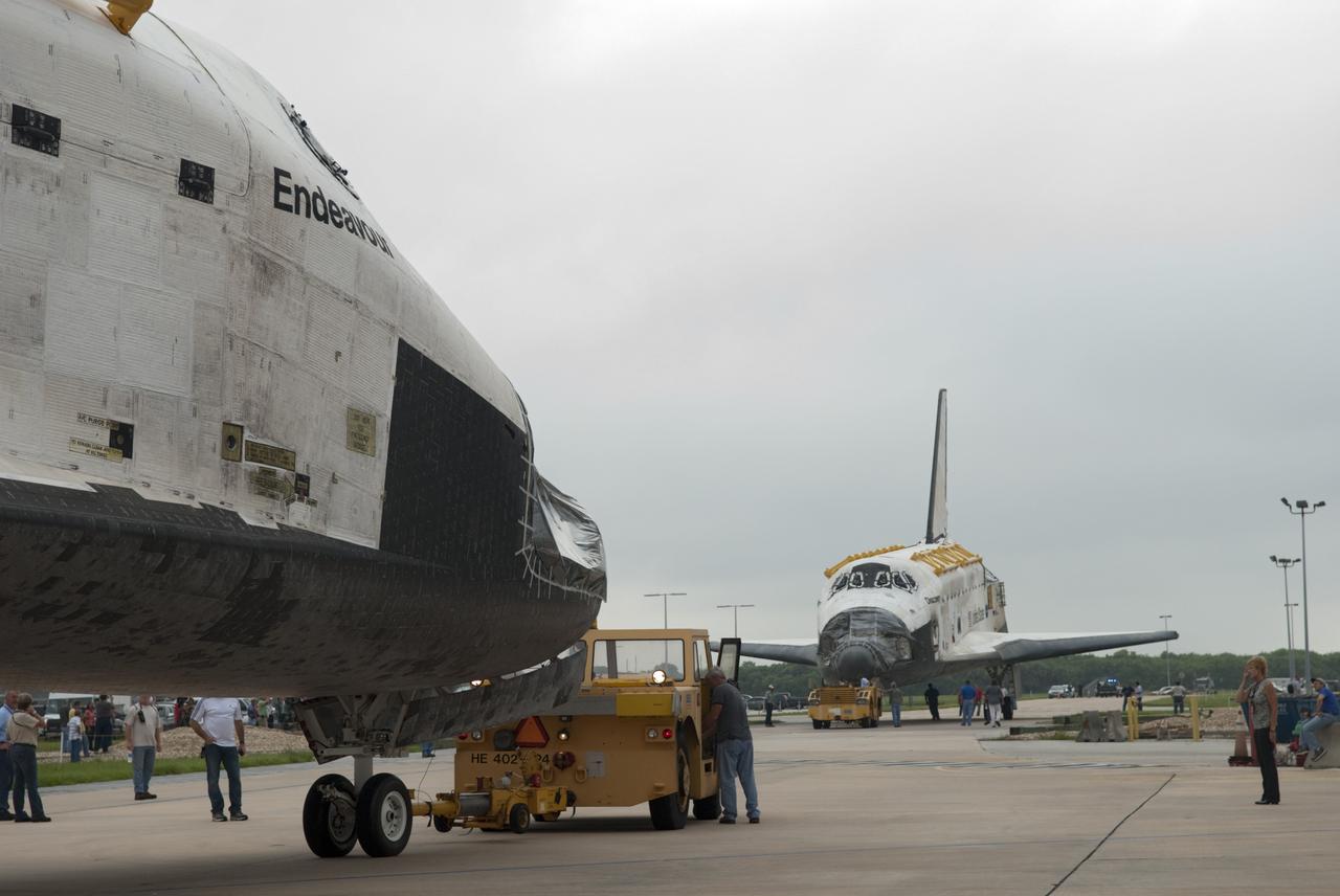 CAPE CANAVERAL, Fla. -- At NASA's Kennedy Space Center in Florida, space shuttles Discovery, at right, and Endeavour pause outside Orbiter Processing Facility-3 (OPF-3) for a unique "nose-to-nose" photo opportunity.  Discovery, which temporarily was being stored in the Vehicle Assembly Building (VAB), is switching places with Endeavour, which has been undergoing decommissioning in OPF-1.  Discovery then will be rolled into OPF-1 and Endeavour into the VAB.    In OPF-1, Discovery will undergo further preparations for public display at the Smithsonian's National Air and Space Museum Steven F. Udvar-Hazy Center in Virginia. Endeavour will be stored in the VAB until October when it will be moved into OPF-2 for further work to get it ready for public display at the California Science Center in Los Angeles.  For more information, visit http://www.nasa.gov/shuttle. Photo credit: NASA/Jim Grossmann