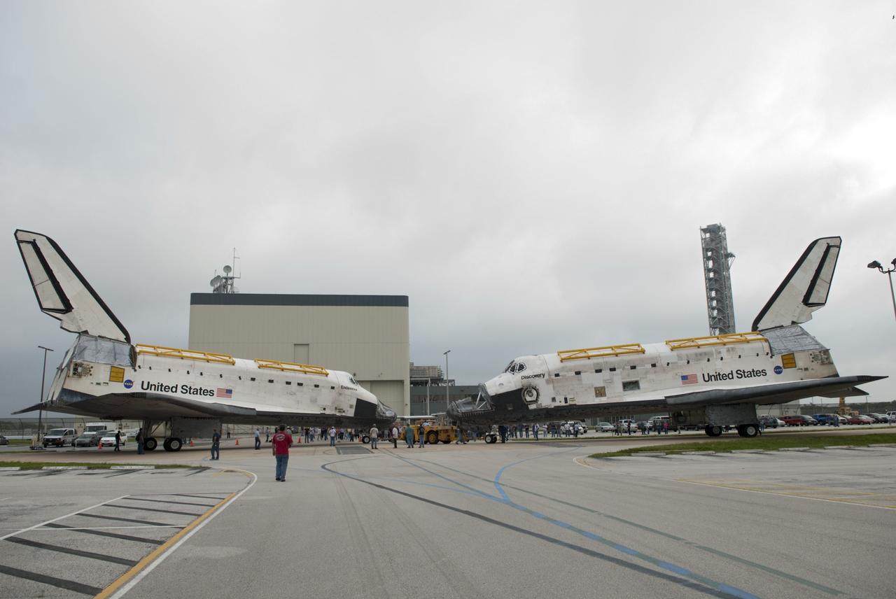 CAPE CANAVERAL, Fla. -- At NASA's Kennedy Space Center in Florida, space shuttles Discovery, at right, and Endeavour are parked "nose-to-nose" outside Orbiter Processing Facility-3 (OPF-3) during a unique photo opportunity.  Discovery, which temporarily was being stored in the Vehicle Assembly Building (VAB), is switching places with Endeavour, which has been undergoing decommissioning in OPF-1.  Discovery then will be rolled into OPF-1 and Endeavour into the VAB.    In OPF-1, Discovery will undergo further preparations for public display at the Smithsonian's National Air and Space Museum Steven F. Udvar-Hazy Center in Virginia. Endeavour will be stored in the VAB until October when it will be moved into OPF-2 for further work to get it ready for public display at the California Science Center in Los Angeles.  For more information, visit http://www.nasa.gov/shuttle. Photo credit: NASA/Jim Grossmann