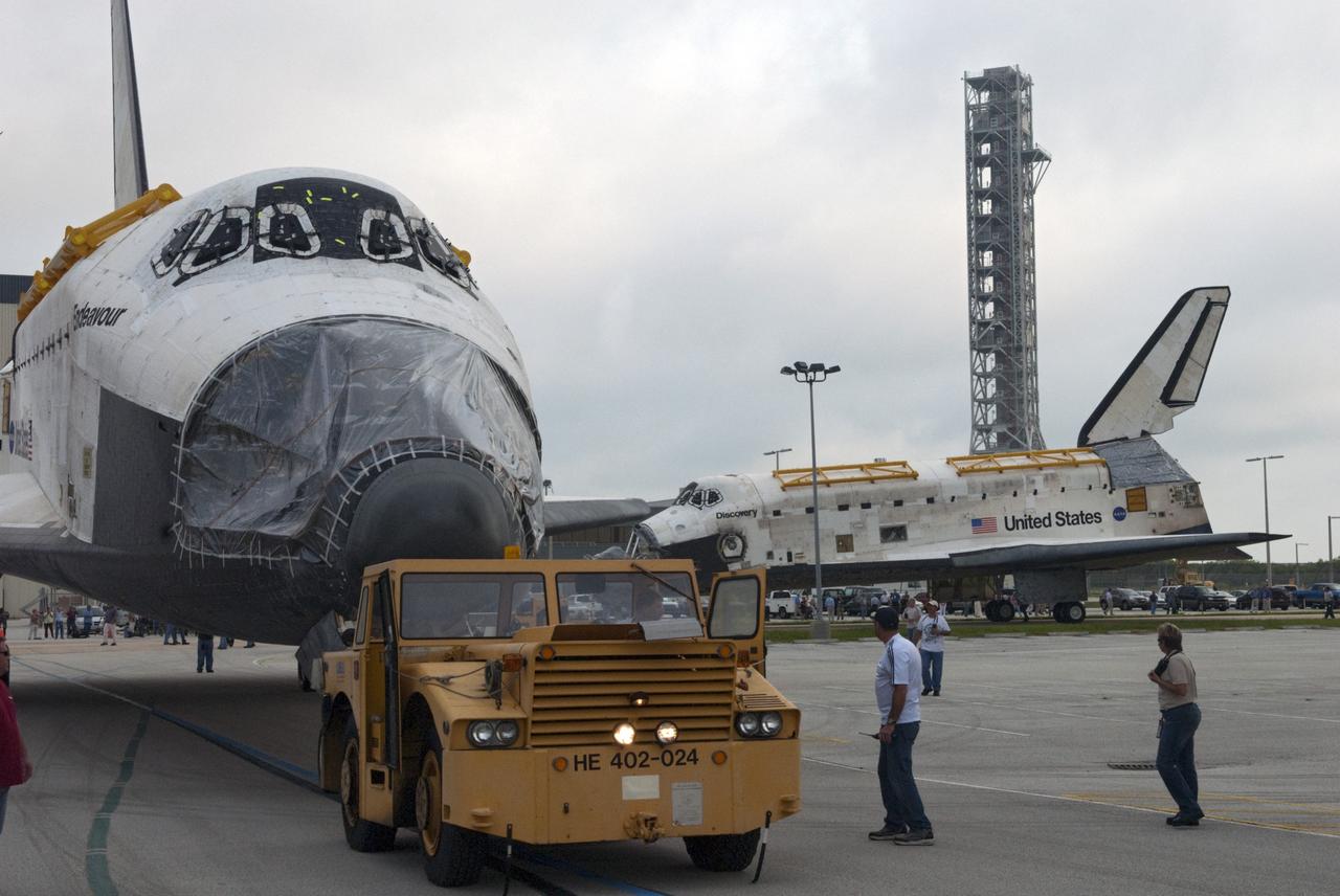 CAPE CANAVERAL, Fla. -- At NASA's Kennedy Space Center in Florida, space shuttles Discovery, at right, and Endeavour part company outside Orbiter Processing Facility-3 (OPF-3) where they paused for a unique "nose-to-nose" photo opportunity.  Discovery, which temporarily was being stored in the Vehicle Assembly Building (VAB), is switching places with Endeavour, which has been undergoing decommissioning in OPF-1.  Discovery will be rolled into OPF-1 and Endeavour into the VAB.    In OPF-1, Discovery will undergo further preparations for public display at the Smithsonian's National Air and Space Museum Steven F. Udvar-Hazy Center in Virginia. Endeavour will be stored in the VAB until October when it will be moved into OPF-2 for further work to get it ready for public display at the California Science Center in Los Angeles.  For more information, visit http://www.nasa.gov/shuttle. Photo credit: NASA/Jim Grossmann