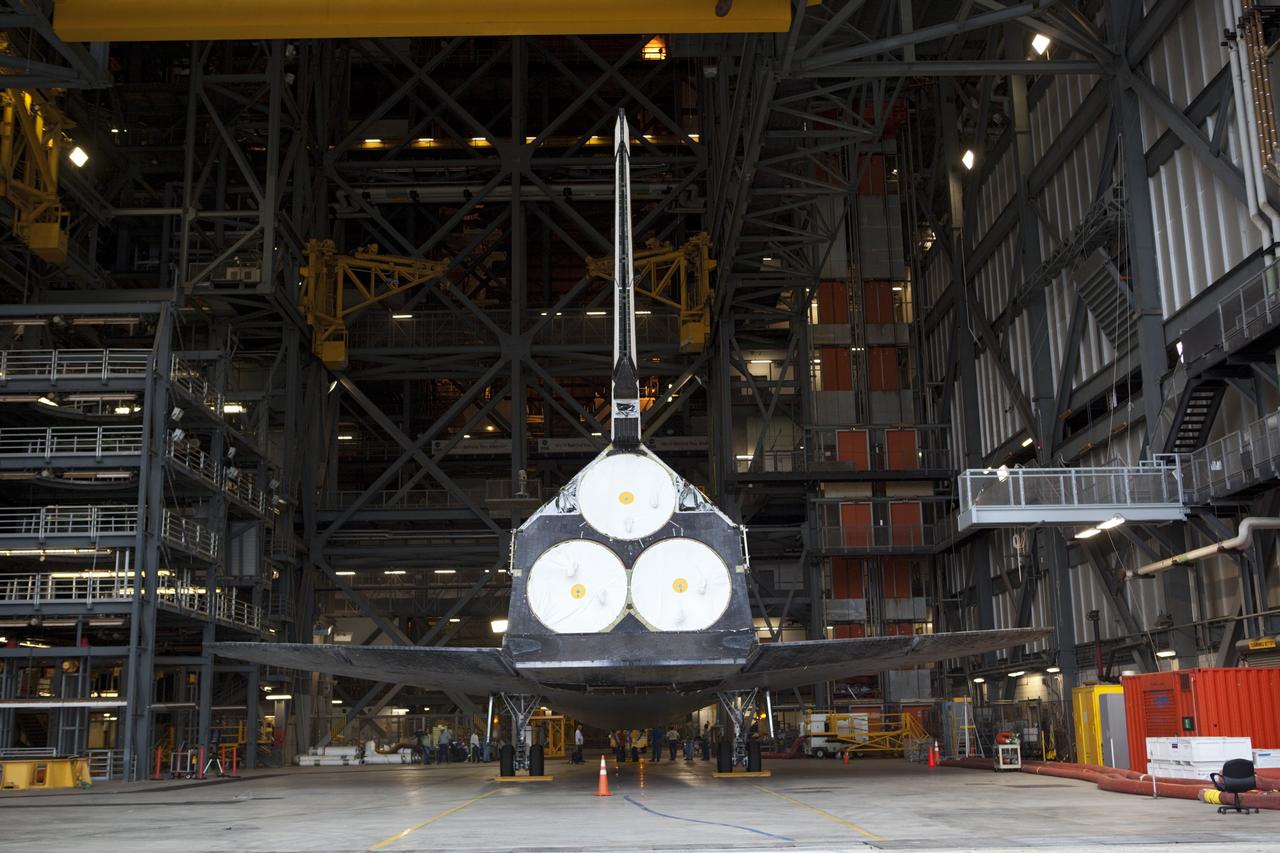 CAPE CANAVERAL, Fla. -- Seen through the open bay door of the Vehicle Assembly Building (VAB) at NASA's Kennedy Space Center in Florida, space shuttle Discovery is being prepared for its move to Orbiter Processing Facility-1 (OPF-1).  Discovery is switching places with shuttle Endeavour which has been undergoing decommissioning activities in OPF-1.  Both shuttles will stop briefly outside OPF-3 for a "nose-to-nose" photo opportunity. Discovery then will be rolled into OPF-1 and Endeavour into the VAB.    In OPF-1, Discovery will undergo further preparations for public display at the Smithsonian's National Air and Space Museum Steven F. Udvar-Hazy Center in Virginia. Endeavour will be stored in the VAB until October when it will be moved into OPF-2 for further work to get it ready for public display at the California Science Center in Los Angeles.  For more information, visit http://www.nasa.gov/shuttle. Photo credit: NASA/Dimitri Gerondidakis
