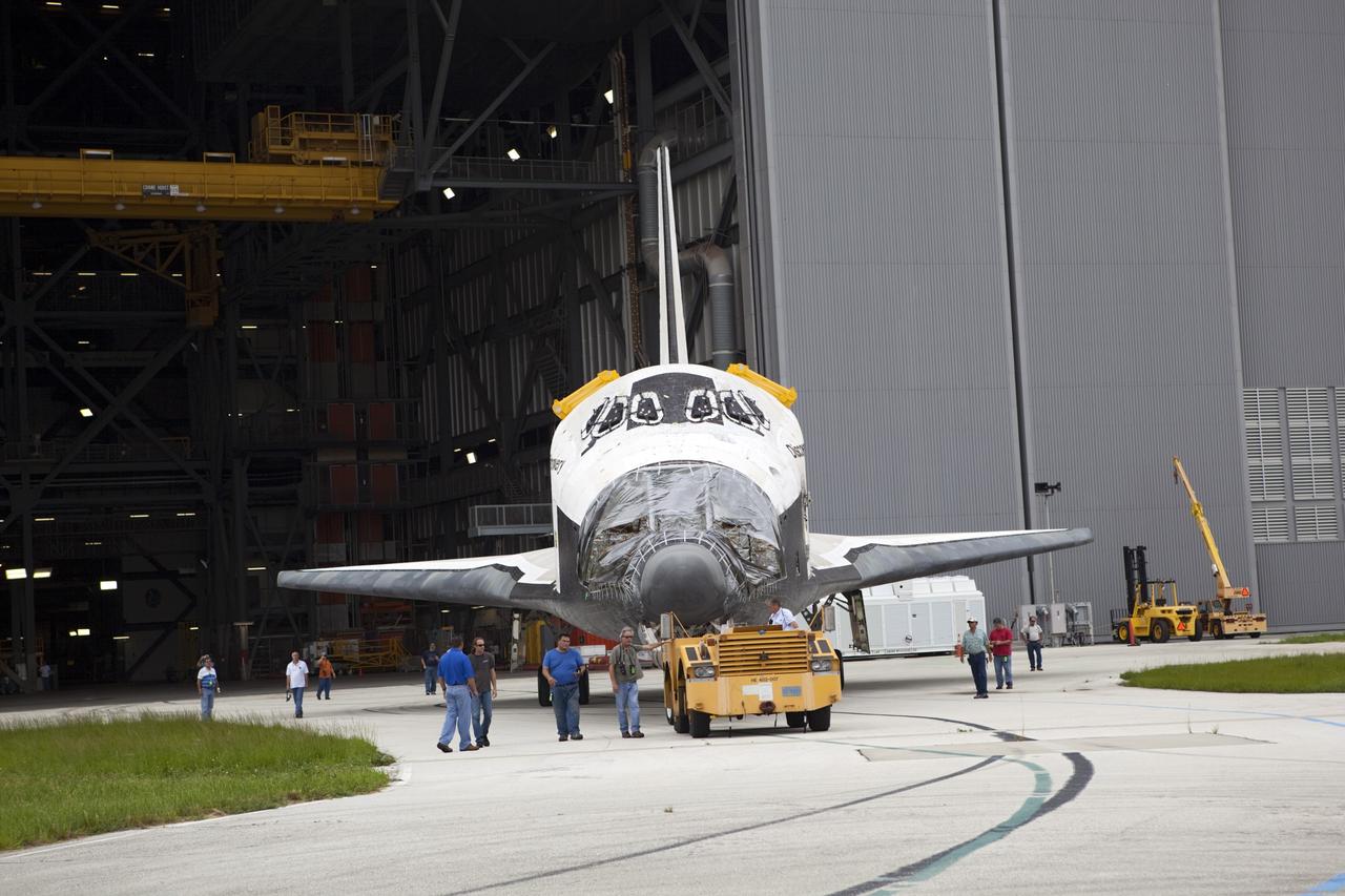 CAPE CANAVERAL, Fla. -- At NASA's Kennedy Space Center in Florida, United Space Alliance employees accompany space shuttle Discovery as it is towed from the Vehicle Assembly Building (VAB), beginning its move to Orbiter Processing Facility-1 (OPF-1).  Discovery is switching places with shuttle Endeavour which has been undergoing decommissioning activities in OPF-1.  Both shuttles will stop briefly outside OPF-3 for a "nose-to-nose" photo opportunity. Discovery then will be rolled into OPF-1 and Endeavour into the VAB.    In OPF-1, Discovery will undergo further preparations for public display at the Smithsonian's National Air and Space Museum Steven F. Udvar-Hazy Center in Virginia. Endeavour will be stored in the VAB until October when it will be moved into OPF-2 for further work to get it ready for public display at the California Science Center in Los Angeles.  For more information, visit http://www.nasa.gov/shuttle. Photo credit: NASA/Dimitri Gerondidakis