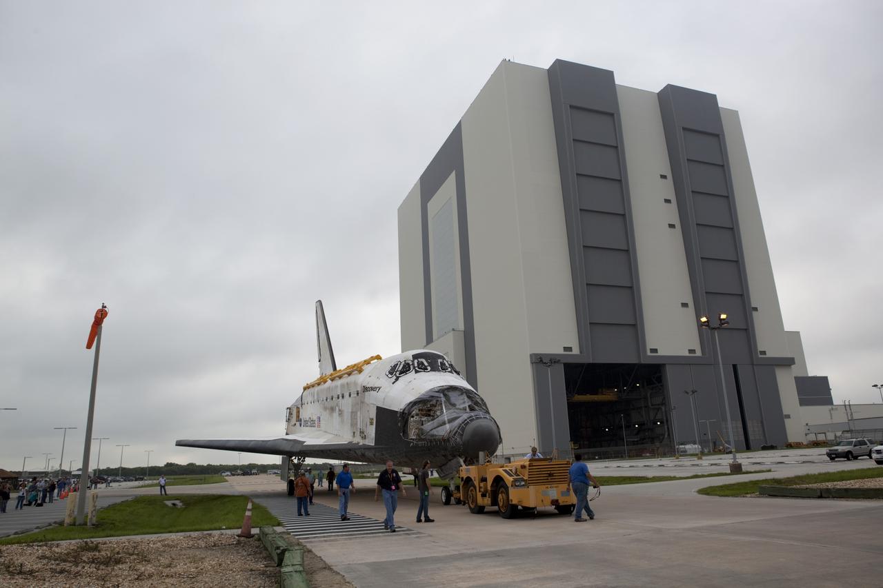 CAPE CANAVERAL, Fla. -- At NASA's Kennedy Space Center in Florida, space shuttle Discovery stops outside the 525-foot-tall Vehicle Assembly Building (VAB), awaiting the arrival of shuttle Endeavour, during its move to the Orbiter Processing Facility-1 (OPF-1).  Discovery is switching places with Endeavour which has been undergoing decommissioning activities in OPF-1.  Both shuttles will stop briefly outside OPF-3 for a "nose-to-nose" photo opportunity. Discovery then will be rolled into OPF-1 and Endeavour into the VAB.    In OPF-1, Discovery will undergo further preparations for public display at the Smithsonian's National Air and Space Museum Steven F. Udvar-Hazy Center in Virginia. Endeavour will be stored in the VAB until October when it will be moved into OPF-2 for further work to get it ready for public display at the California Science Center in Los Angeles.  For more information, visit http://www.nasa.gov/shuttle. Photo credit: NASA/Dimitri Gerondidakis
