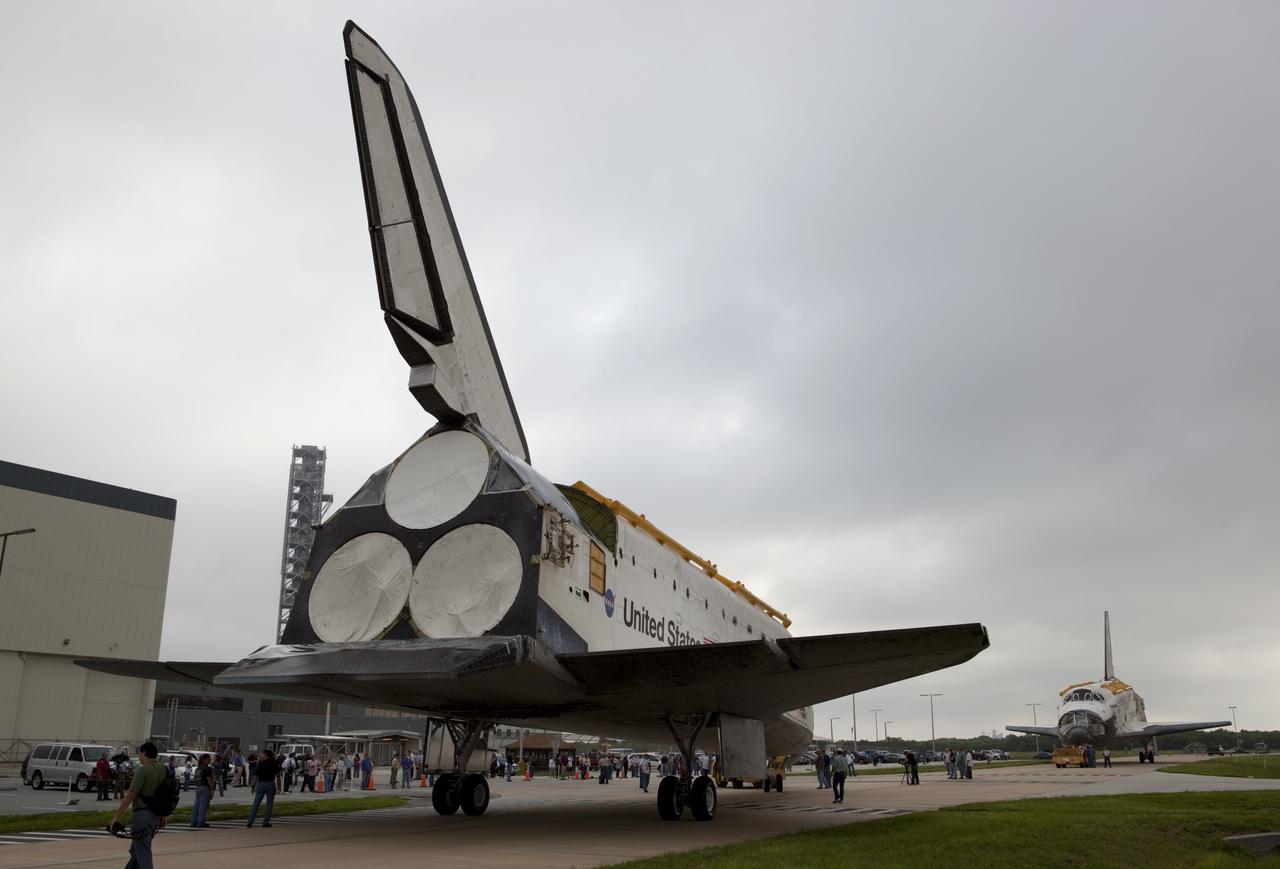 CAPE CANAVERAL, Fla. -- At NASA's Kennedy Space Center in Florida, space shuttle Endeavour, in the distance, approaches shuttle Discovery during its move to the Vehicle Assembly Building (VAB). Discovery is switching places with Endeavour which has been undergoing decommissioning activities in Orbiter Processing Facility-1 (OPF-1).  Both shuttles will stop briefly outside OPF-3 for a "nose-to-nose" photo opportunity. Discovery then will be rolled into OPF-1 and Endeavour into the VAB.    In OPF-1, Discovery will undergo further preparations for public display at the Smithsonian's National Air and Space Museum Steven F. Udvar-Hazy Center in Virginia. Endeavour will be stored in the VAB until October when it will be moved into OPF-2 for further work to get it ready for public display at the California Science Center in Los Angeles.  For more information, visit http://www.nasa.gov/shuttle. Photo credit: NASA/Dimitri Gerondidakis