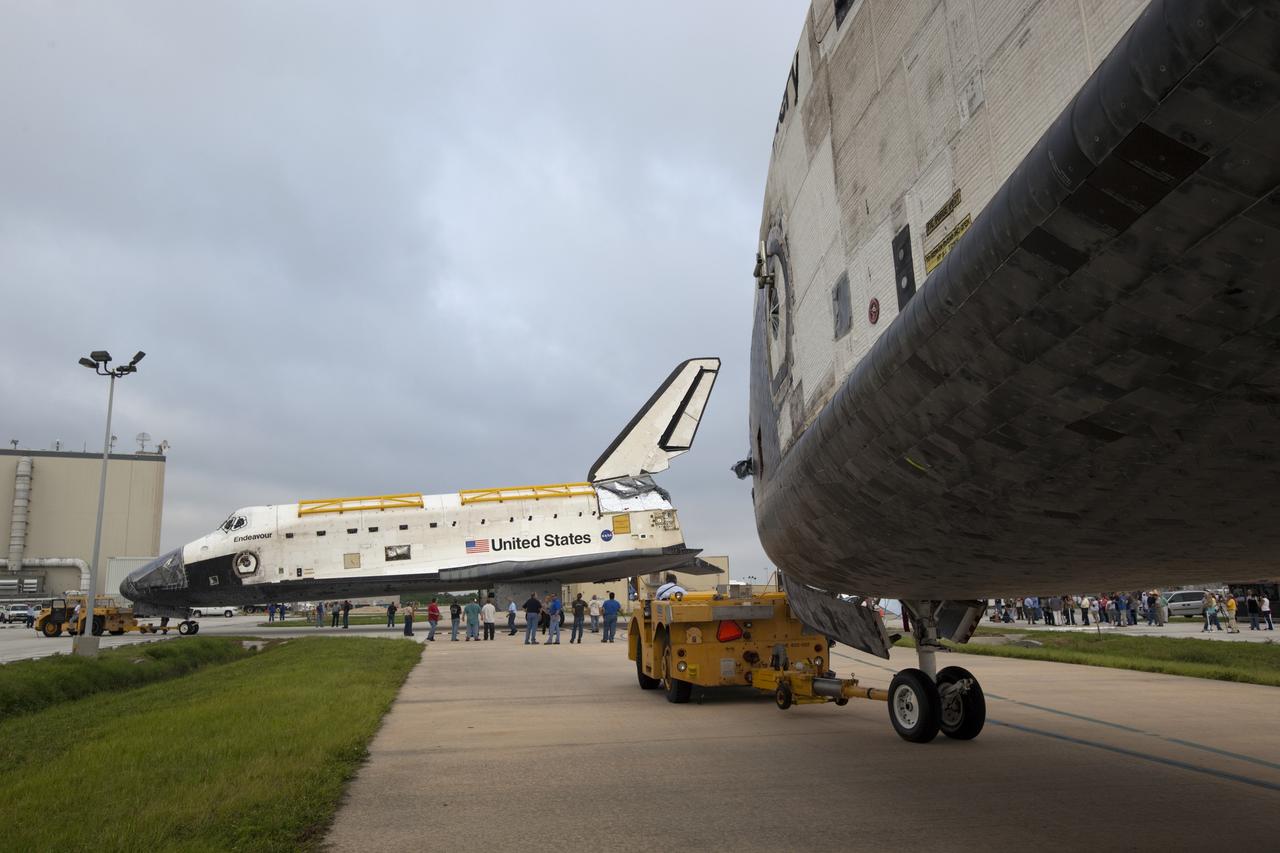 CAPE CANAVERAL, Fla. -- At NASA's Kennedy Space Center in Florida, space shuttles Discovery and Endeavour continue on their separate ways outside Orbiter Processing Facility-3 (OPF-3) where they paused for a unique "nose-to-nose" photo opportunity.  Discovery, which temporarily was being stored in the Vehicle Assembly Building (VAB), is switching places with Endeavour, which has been undergoing decommissioning in OPF-1.  Discovery will be rolled into OPF-1 and Endeavour into the VAB.    In OPF-1, Discovery will undergo further preparations for public display at the Smithsonian's National Air and Space Museum Steven F. Udvar-Hazy Center in Virginia. Endeavour will be stored in the VAB until October when it will be moved into OPF-2 for further work to get it ready for public display at the California Science Center in Los Angeles.  For more information, visit http://www.nasa.gov/shuttle. Photo credit: NASA/Dimitri Gerondidakis