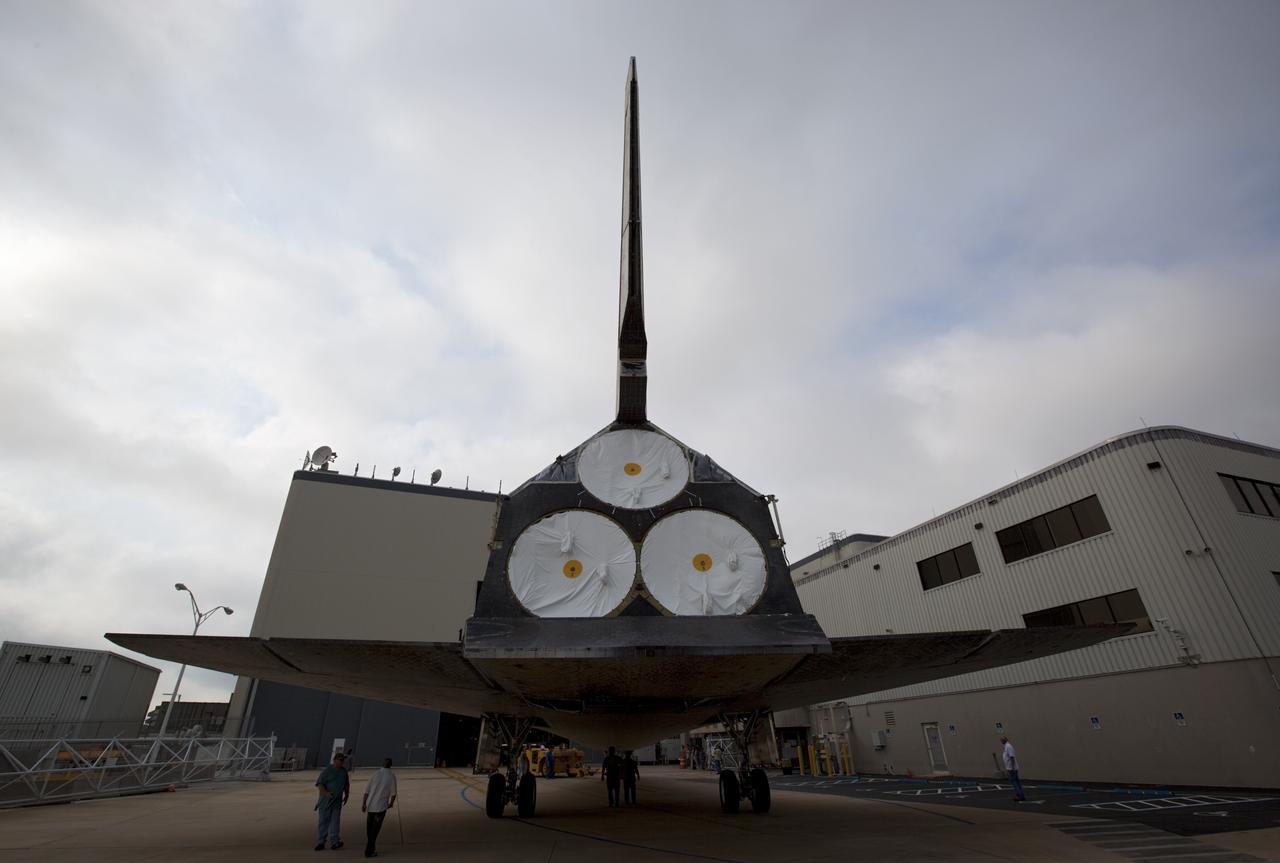 CAPE CANAVERAL, Fla. -- At NASA's Kennedy Space Center in Florida, United Space Alliance workers tow space shuttle Discovery into position to enter Orbiter Processing Facility-1 (OPF-1).  Discovery is switching places with shuttle Endeavour which temporarily is being placed in storage in the Vehicle Assembly Building (VAB).  Both shuttles stopped briefly outside OPF-3 for a "nose-to-nose" photo opportunity.     In OPF-1, Discovery will undergo further preparations for public display at the Smithsonian's National Air and Space Museum Steven F. Udvar-Hazy Center in Virginia. Endeavour will be stored in the VAB until October when it will be moved into OPF-2 for further work to get it ready for public display at the California Science Center in Los Angeles.  For more information, visit http://www.nasa.gov/shuttle. Photo credit: NASA/Dimitri Gerondidakis
