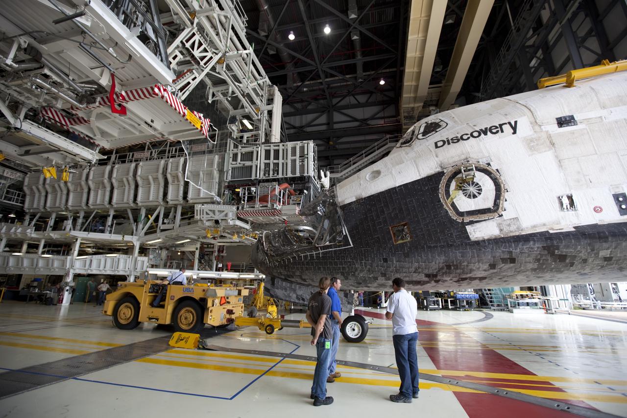 CAPE CANAVERAL, Fla. -- At NASA's Kennedy Space Center in Florida, space shuttle Discovery is towed toward the work platforms in  Orbiter Processing Facility-1 (OPF-1) after participating in a unique "nose-to-nose" photo opportunity outside OPF-3 with shuttle Endeavour. Discovery is switching places with Endeavour which temporarily is being placed in storage in the Vehicle Assembly Building (VAB).    In OPF-1, Discovery will undergo further preparations for public display at the Smithsonian's National Air and Space Museum Steven F. Udvar-Hazy Center in Virginia. Endeavour will be stored in the VAB until October when it will be moved into OPF-2 for further work to get it ready for public display at the California Science Center in Los Angeles.  For more information, visit http://www.nasa.gov/shuttle. Photo credit: NASA/Dimitri Gerondidakis