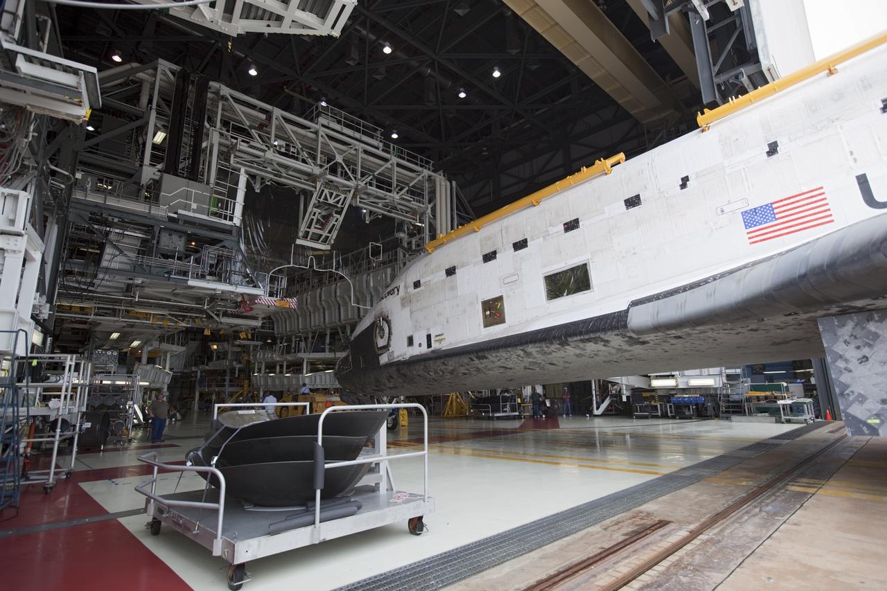 CAPE CANAVERAL, Fla. -- At NASA's Kennedy Space Center in Florida, space shuttle Discovery is towed toward the work platforms in  Orbiter Processing Facility-1 (OPF-1) after participating in a unique "nose-to-nose" photo opportunity outside OPF-3 with shuttle Endeavour. Discovery is switching places with Endeavour which temporarily is being placed in storage in the Vehicle Assembly Building (VAB).    In OPF-1, Discovery will undergo further preparations for public display at the Smithsonian's National Air and Space Museum Steven F. Udvar-Hazy Center in Virginia. Endeavour will be stored in the VAB until October when it will be moved into OPF-2 for further work to get it ready for public display at the California Science Center in Los Angeles.  For more information, visit http://www.nasa.gov/shuttle. Photo credit: NASA/Dimitri Gerondidakis