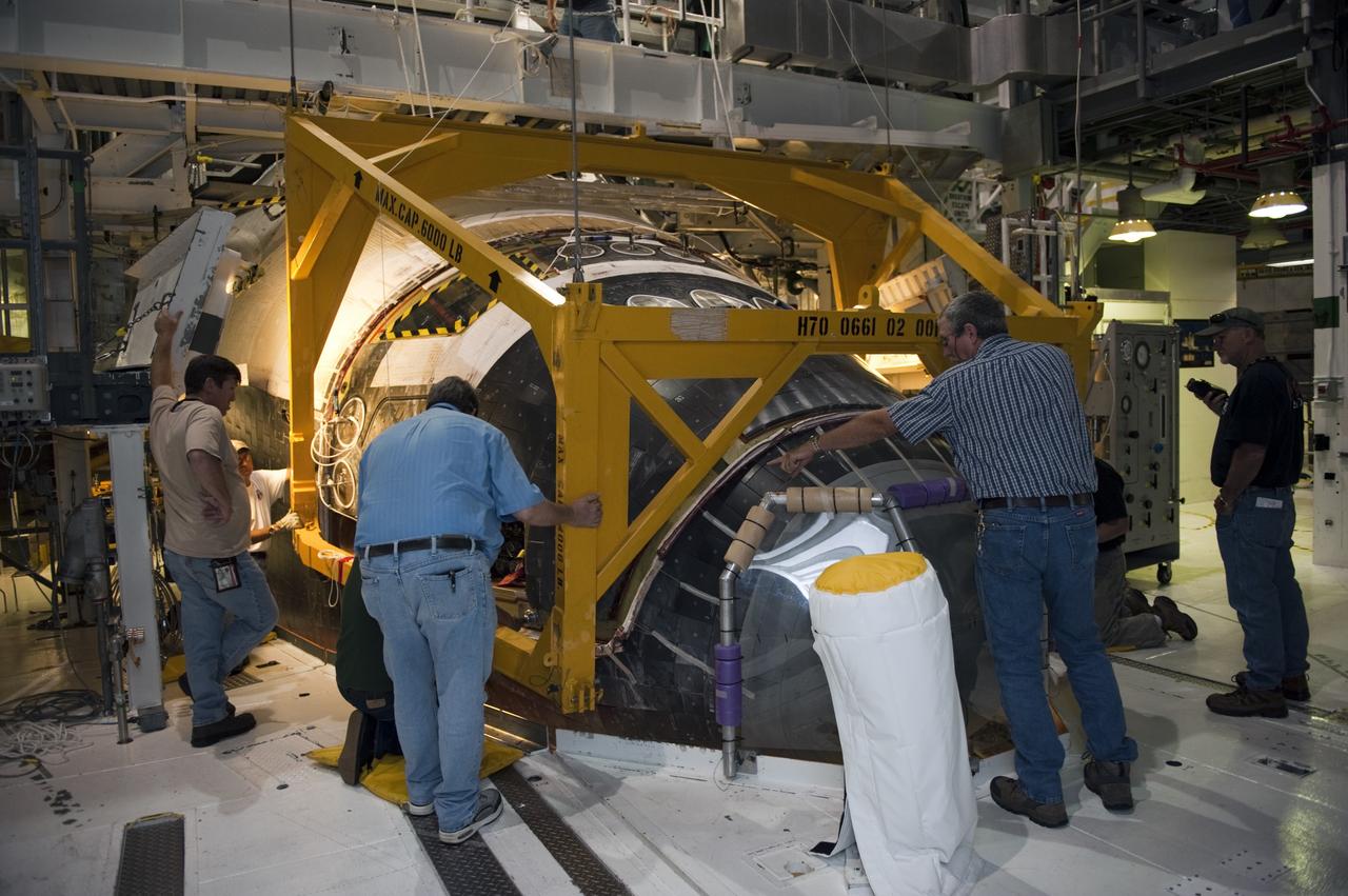 CAPE CANAVERAL, Fla. -- In Orbiter Processing Facility-2 (OPF-2) at NASA’s Kennedy Space Center in Florida, technicians help position a special crane around space shuttle Atlantis so that work can begin to remove the spacecraft’s forward reaction control system. The system provided some of the maneuvering capabilities to the spacecraft during its missions. Atlantis glided to a landing, July 21, 2011, at Kennedy Space Center’s Shuttle Landing Facility, completing NASA’s final space shuttle mission, STS-135. The shuttle is in OPF-2 being decommissioned and prepared for eventual display at the Kennedy Space Center Visitor Complex in Florida. Photo credit: Kim Shiflett