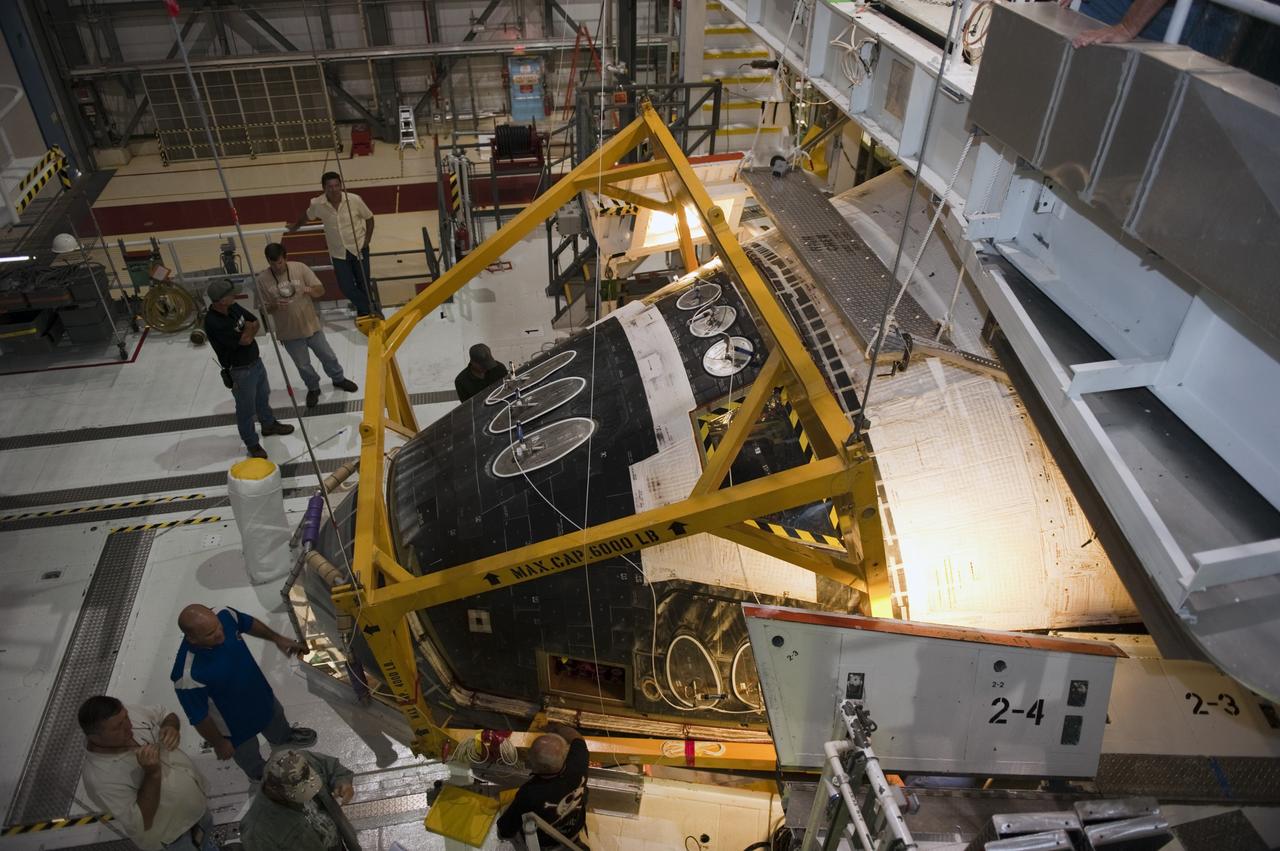 CAPE CANAVERAL, Fla. -- In Orbiter Processing Facility-2 (OPF-2) at NASA’s Kennedy Space Center in Florida, technicians help position a special crane around space shuttle Atlantis so that work can begin to remove the spacecraft’s forward reaction control system. The system provided some of the maneuvering capabilities to the spacecraft during its missions. Atlantis glided to a landing, July 21, 2011, at Kennedy Space Center’s Shuttle Landing Facility, completing NASA’s final space shuttle mission, STS-135. The shuttle is in OPF-2 being decommissioned and prepared for eventual display at the Kennedy Space Center Visitor Complex in Florida. Photo credit: Kim Shiflett