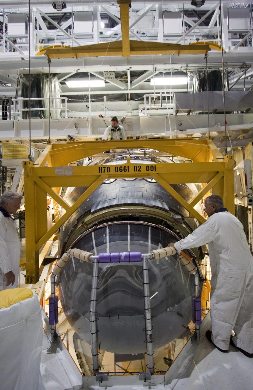 CAPE CANAVERAL, Fla. -- In Orbiter Processing Facility-2 (OPF-2) at NASA’s Kennedy Space Center in Florida, technicians help guide a special crane around space shuttle Atlantis so that work can begin to remove its forward reaction control system. The system provided maneuvering capabilities to the spacecraft during its missions. Atlantis glided to a landing, July 21, 2011, at Kennedy Space Center’s Shuttle Landing Facility, completing NASA’s final space shuttle mission, STS-135. The shuttle is in OPF-2 being decommissioned and prepared for eventual display at the Kennedy Space Center Visitor Complex in Florida. Photo credit: Jim Grossmann