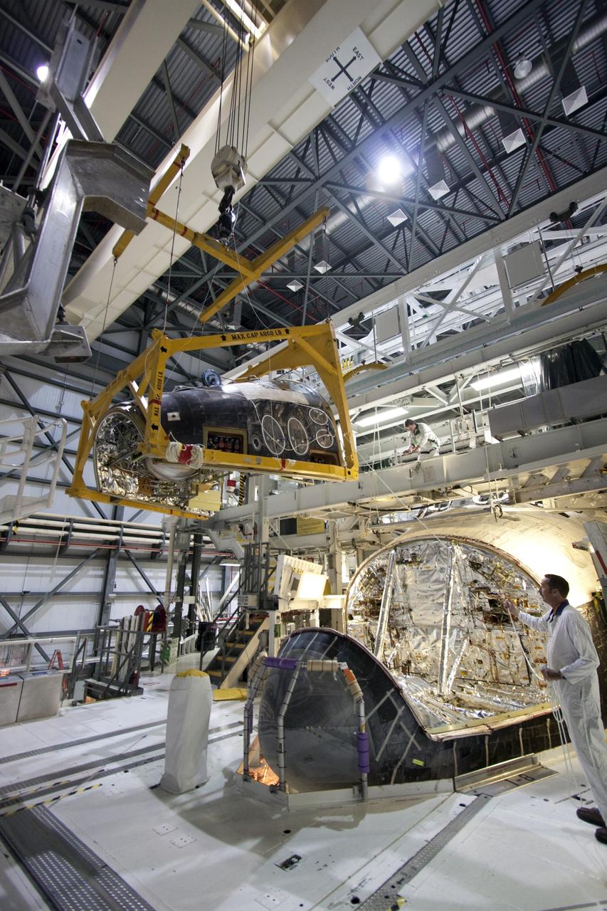 CAPE CANAVERAL, Fla. -- In Orbiter Processing Facility-2 (OPF-2) at NASA’s Kennedy Space Center in Florida, a technician monitors the progress of a special crane as it lifts the forward reaction control system away from space shuttle Atlantis. The system provided some of the maneuvering capabilities to the spacecraft during its missions. Atlantis glided to a landing, July 21, 2011, at Kennedy Space Center’s Shuttle Landing Facility, completing NASA’s final space shuttle mission, STS-135. The shuttle is in OPF-2 being decommissioned and prepared for eventual display at the Kennedy Space Center Visitor Complex in Florida. Photo credit: Jim Grossmann
