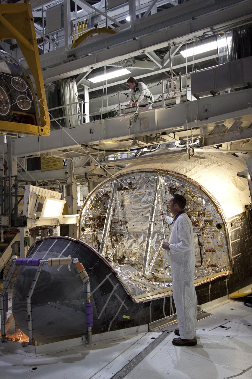 CAPE CANAVERAL, Fla. -- In Orbiter Processing Facility-2 (OPF-2) at NASA’s Kennedy Space Center in Florida, technicians monitor the progress of a special crane as it lifts the forward reaction control system away from space shuttle Atlantis. The system provided some of the maneuvering capabilities to the spacecraft during its missions. Atlantis glided to a landing, July 21, 2011, at Kennedy Space Center’s Shuttle Landing Facility, completing NASA’s final space shuttle mission, STS-135. The shuttle is in OPF-2 being decommissioned and prepared for eventual display at the Kennedy Space Center Visitor Complex in Florida. Photo credit: Jim Grossmann