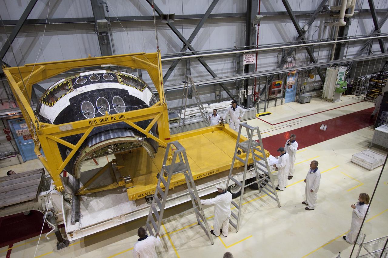 CAPE CANAVERAL, Fla. -- In Orbiter Processing Facility-2 (OPF-2) at NASA’s Kennedy Space Center in Florida, technicians assist as a special crane lowers space shuttle Atlantis’ forward reaction control system onto a transporter. The system, which provided maneuvering capabilities to the spacecraft during its missions, will be transported to White Sands Space Harbor in New Mexico to undergo a complete deservicing and cleaning. Atlantis glided to a landing, July 21, 2011, at Kennedy Space Center’s Shuttle Landing Facility, completing NASA’s final space shuttle mission, STS-135. The shuttle is in OPF-2 being decommissioned and prepared for eventual display at the Kennedy Space Center Visitor Complex in Florida. Photo credit: Jim Grossmann