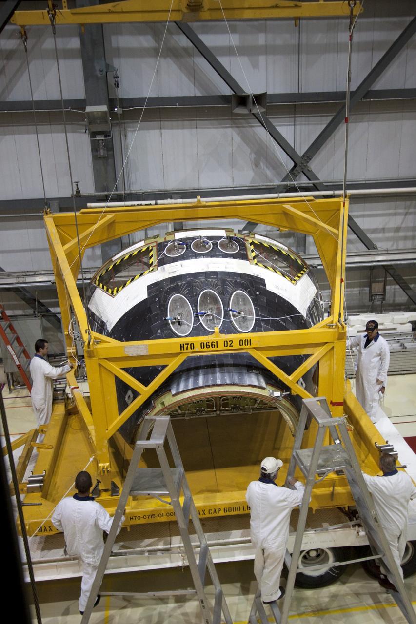 CAPE CANAVERAL, Fla. -- In Orbiter Processing Facility-2 (OPF-2) at NASA’s Kennedy Space Center in Florida, technicians assist as a special crane lowers space shuttle Atlantis’ forward reaction control system onto a transporter. The system, which provided maneuvering capabilities to the spacecraft during its missions, will be transported to White Sands Space Harbor in New Mexico to undergo a complete deservicing and cleaning. Atlantis glided to a landing, July 21, 2011, at Kennedy Space Center’s Shuttle Landing Facility, completing NASA’s final space shuttle mission, STS-135. The shuttle is in OPF-2 being decommissioned and prepared for eventual display at the Kennedy Space Center Visitor Complex in Florida. Photo credit: Jim Grossmann