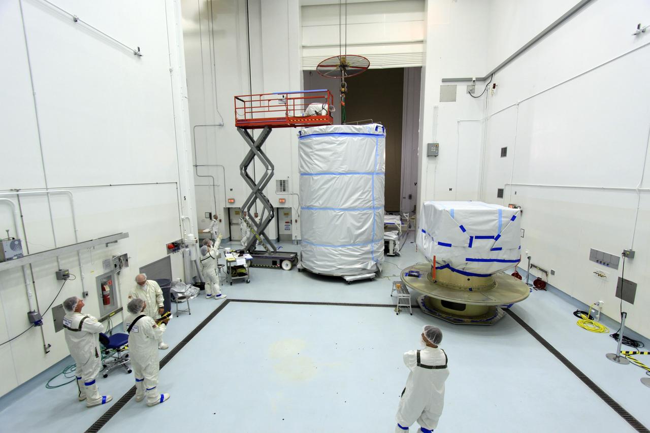 CAPE CANAVERAL, Fla. -- At Astrotech Space Operation's payload processing facility in Titusville, Fla., preparations are under way to enclose NASA's twin Gravity Recovery and Interior Laboratory spacecraft, at right, in a protective canister for transport to the launch pad.  The lunar probes are attached to a spacecraft adapter ring in their side-by-side launch configuration and wrapped in plastic to prevent contamination outside the clean room.    The spacecraft will fly in tandem orbits around the moon for several months to measure its gravity field. GRAIL's primary science objectives are to determine the structure of the lunar interior, from crust to core, and to advance understanding of the thermal evolution of the moon.  Launch aboard a United Launch Alliance Delta II rocket from Space Launch Complex 17B on Cape Canaveral Air Force Station is scheduled for Sept. 8.  For more information, visit http://www.nasa.gov/grail. Photo credit: NASA/Jim Grossmann