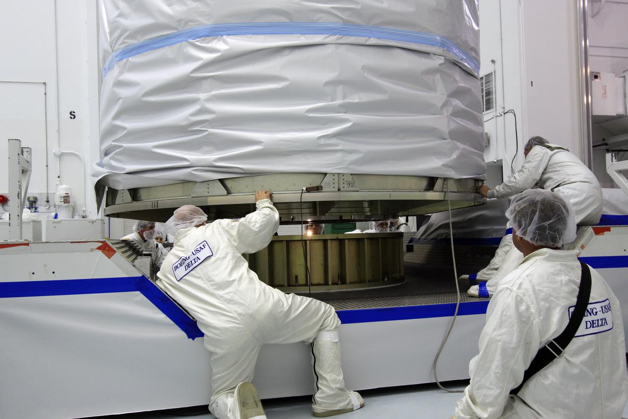 CAPE CANAVERAL, Fla. -- At Astrotech Space Operation's payload processing facility in Titusville, Fla., Lockheed Martin technicians guide the protective canister enclosing NASA's twin Gravity Recovery and Interior Laboratory spacecraft into place on a transportation pallet.  Preparations are under way to move the lunar probes, attached to a spacecraft adapter ring in their side-by-side launch configuration, to the launch pad.    The spacecraft will fly in tandem orbits around the moon for several months to measure its gravity field. GRAIL's primary science objectives are to determine the structure of the lunar interior, from crust to core, and to advance understanding of the thermal evolution of the moon.  Launch aboard a United Launch Alliance Delta II rocket from Space Launch Complex 17B on Cape Canaveral Air Force Station is scheduled for Sept. 8.  For more information, visit http://www.nasa.gov/grail. Photo credit: NASA/Jim Grossmann