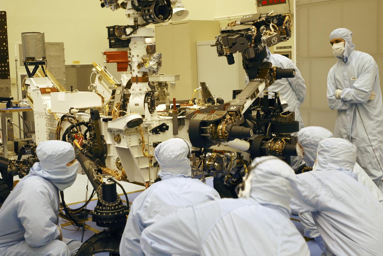 CAPE CANAVERAL, Fla. -- In the Payload Hazardous Servicing Facility at Kennedy Space Center in Florida, spacecraft technicians monitor the movement of the robotic arm of the Mars Science Laboratory (MSL) rover, Curiosity, as it is stowed against the body of the spacecraft. The arm will hold and maneuver instruments that will help scientists analyze Martian rocks and soil. Much like a human arm, the robotic arm has flexibility through shoulder, elbow, and wrist joints that permit the arm to extend, bend, and angle precisely against rocks and soil to grind away layers, take microscopic images and analyze their elemental composition. At the end of the arm is a hand-like structure, the turret, for holding various tools that can spin through a 350-degree turning range. A United Launch Alliance Atlas V-541 configuration will be used to loft MSL into space. Curiosity’s 10 science instruments are designed to search for evidence on whether Mars has had environments favorable to microbial life, including chemical ingredients for life. The unique rover will use a laser to look inside rocks and release its gasses so that the rover’s spectrometer can analyze and send the data back to Earth. MSL is scheduled to launch Nov. 25 from Space Launch Complex 41 on Cape Canaveral Air Force Station in Florida. For more information, visit http://www.nasa.gov/msl. Photo credit: NASA/Charisse Nahser