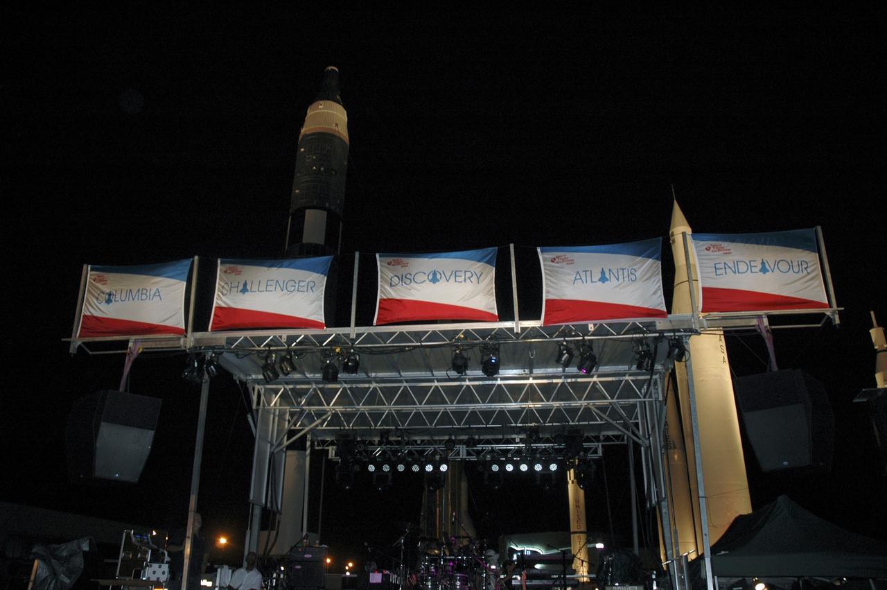 CAPE CANAVERAL, Fla. -- With the Rocket Garden for a backdrop, five shuttle flags hang above the main stage at NASA Kennedy Space Center’s “We Made History! Shuttle Program Celebration,” Aug. 13, at the Kennedy Space Center Visitor Complex, Fla. The event was held to honor current and former shuttle workers’ dedication to NASA’s Space Shuttle Program and to celebrate 30 years of space shuttle achievements. The event featured food, music, entertainment, astronaut appearances, educational activities, giveaways, and Starfire Night Skyshow. Photo credit: Gianni Woods