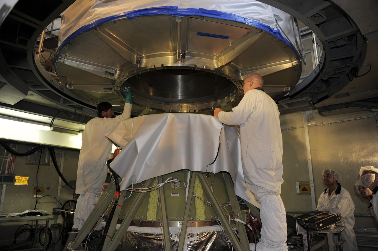 CAPE CANAVERAL, Fla. -- Technicians lower NASA's twin Gravity Recovery and Interior Laboratory (GRAIL) spacecraft into place atop a United Launch Alliance Delta II rocket on Space Launch Complex 17B at Cape Canaveral Air Force Station in Florida. The lunar probes are attached to a spacecraft adapter ring in their side-by-side launch configuration and wrapped in plastic to prevent contamination outside the clean room.      The spacecraft will fly in tandem orbits around the moon for several months to measure its gravity field. GRAIL's primary science objectives are to determine the structure of the lunar interior, from crust to core, and to advance understanding of the thermal evolution of the moon.  Launch is scheduled for Sept. 8. For more information, visit www.nasa.gov/grail. Photo credit: NASA/Kim Shiflett