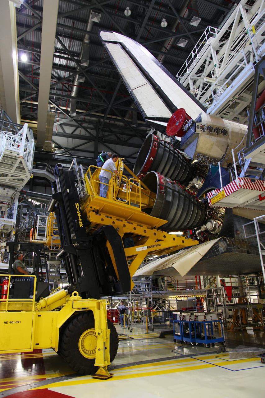 CAPE CANAVERAL, Fla. -- In Orbiter Processing Facility-2 at NASA’s Kennedy Space Center in Florida, technicians use a Hyster forklift to position an engine removal device on Engine #3 on space shuttle Atlantis. The forklift will be used to remove the engine and transport it to the Engine Shop for possible future use. Each of the three space shuttle main engines is 14 feet long and weighs 7,800 pounds. Removal of the space shuttle main engines is part of the Transition and Retirement work that is being performed in order to prepare Atlantis for eventual display at the Kennedy Space Center Visitor Complex in Florida. Photo credit: Frankie Martin