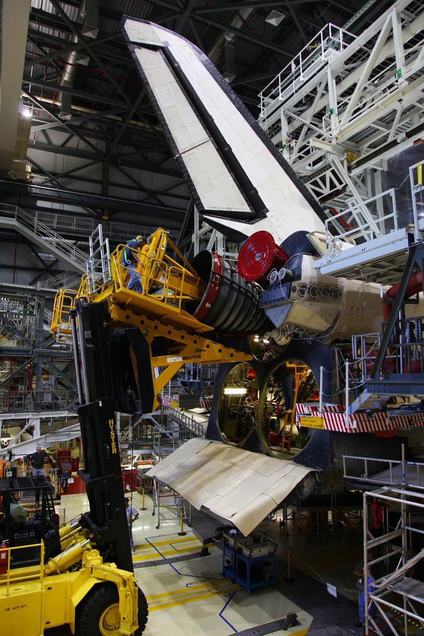 CAPE CANAVERAL, Fla. -- In Orbiter Processing Facility-2 at NASA’s Kennedy Space Center in Florida, a technician sitting on the Hyster forklift monitors the progress as the engine removal device moves toward Engine #1, the final engine to be removed from space shuttle Atlantis. The forklift will be used to remove the engine and transport it to the Engine Shop for possible future use. Each of the three space shuttle main engines is 14 feet long and weighs 7,800 pounds. Removal of the space shuttle main engines is part of the Transition and Retirement work that is being performed in order to prepare Atlantis for eventual display at the Kennedy Space Center Visitor Complex in Florida. Photo credit: Frankie Martin