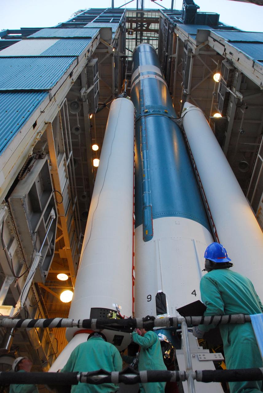 VANDENBERG AIR FORCE BASE, Calif. -- At Vandenberg Air Force Base in California, technicians monitor the progress as a crane lifts a solid rocket motor into position for attachment to the United Launch Alliance Delta II that will carry NASA's National Polar-orbiting Operational Environmental Satellite System Preparatory Project (NPP) satellite at NASA's Space Launch Complex-2. NPP represents a critical first step in building the next-generation of Earth-observing satellites. NPP will carry the first of the new sensors developed for this satellite fleet, now known as the Joint Polar Satellite System (JPSS) to be launched in 2016. NPP is the bridge between NASA's Earth Observing System (EOS) satellites and the forthcoming series of JPSS satellites. The mission will test key technologies and instruments for the JPSS missions. NPP is targeted to launch Oct. 25. For more information, visit http://www.nasa.gov/NPP. Photo credit: NASA/VAFB, Dan Liberotti