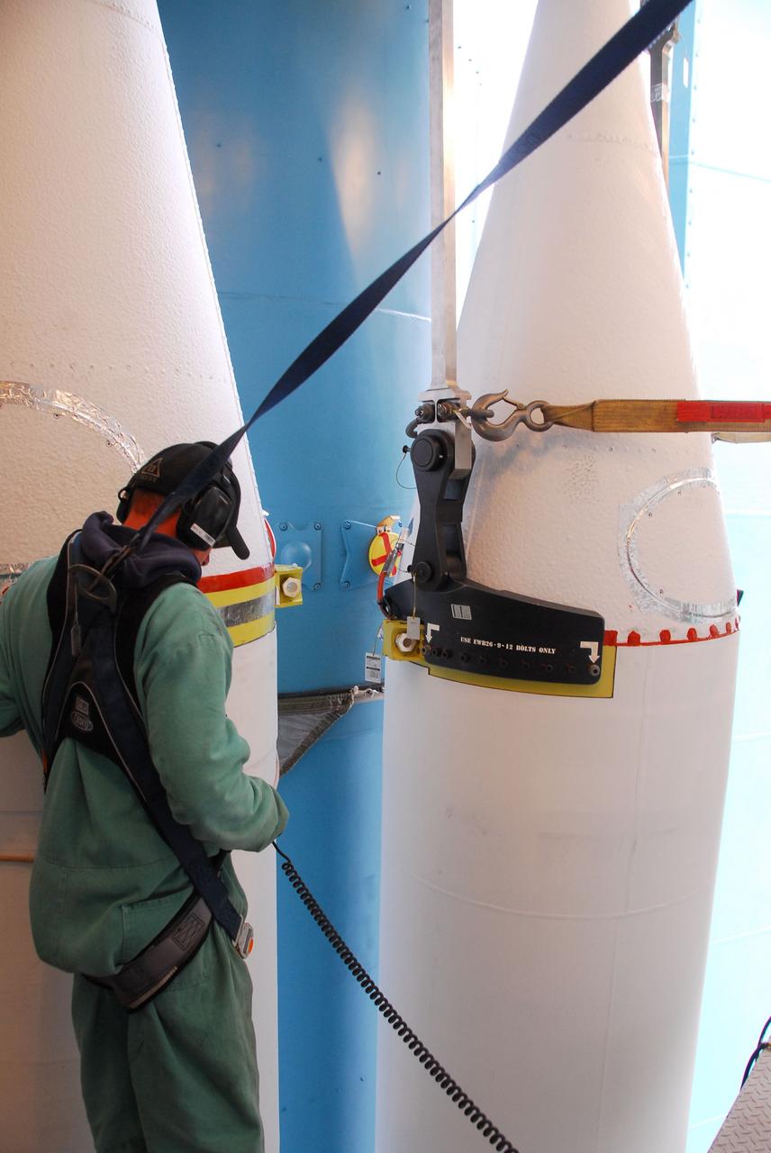 VANDENBERG AIR FORCE BASE, Calif. -- At NASA’s Space Launch Complex-2 at Vandenberg Air Force Base in California, a technician in a safety harness monitors the progress as a solid rocket motor is attached to the United Launch Alliance Delta II rocket. The Delta II will carry NASA's National Polar-orbiting Operational Environmental Satellite System Preparatory Project (NPP) satellite into space. NPP represents a critical first step in building the next-generation of Earth-observing satellites. NPP will carry the first of the new sensors developed for this satellite fleet, now known as the Joint Polar Satellite System (JPSS) to be launched in 2016. NPP is the bridge between NASA's Earth Observing System (EOS) satellites and the forthcoming series of JPSS satellites. The mission will test key technologies and instruments for the JPSS missions. NPP is targeted to launch Oct. 25. For more information, visit http://www.nasa.gov/NPP. Photo credit: NASA/VAFB, Dan Liberotti