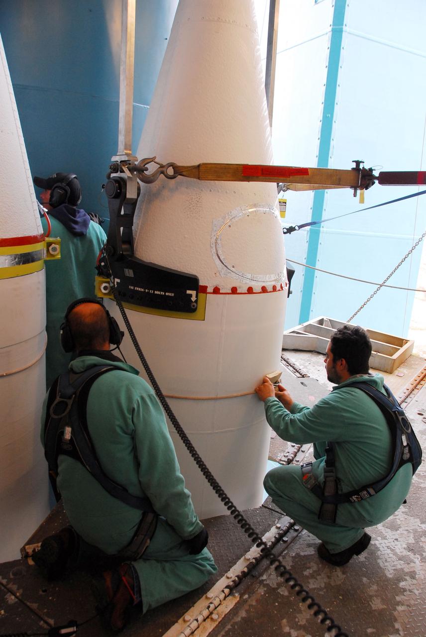VANDENBERG AIR FORCE BASE, Calif. -- At NASA’s Space Launch Complex-2 at Vandenberg Air Force Base in California, technicians wearing safety harnesses prepare a solid rocket motor to be attached to the United Launch Alliance Delta II rocket. The Delta II will carry NASA's National Polar-orbiting Operational Environmental Satellite System Preparatory Project (NPP) satellite into space. NPP represents a critical first step in building the next-generation of Earth-observing satellites. NPP will carry the first of the new sensors developed for this satellite fleet, now known as the Joint Polar Satellite System (JPSS) to be launched in 2016. NPP is the bridge between NASA's Earth Observing System (EOS) satellites and the forthcoming series of JPSS satellites. The mission will test key technologies and instruments for the JPSS missions. NPP is targeted to launch Oct. 25. For more information, visit http://www.nasa.gov/NPP. Photo credit: NASA/VAFB, Dan Liberotti