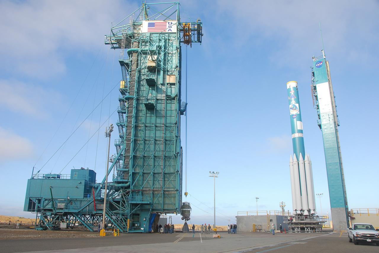 VANDENBERG AIR FORCE BASE, Calif. -- At Vandenberg Air Force Base in California, the AJ10 engine for the second stage of a United Launch Alliance Delta II rocket is hoisted up in the service tower at NASA’s Space Launch Complex 2. The rocket’s third stage with several solid rocket motors attached sits on the launch pad to the right. The Delta II will carry NASA's National Polar-orbiting Operational Environmental Satellite System Preparatory Project (NPP) satellite into space.    NPP represents a critical first step in building the next-generation of Earth-observing satellites. NPP will carry the first of the new sensors developed for this satellite fleet, now known as the Joint Polar Satellite System (JPSS) to be launched in 2016. NPP is the bridge between NASA's Earth Observing System (EOS) satellites and the forthcoming series of JPSS satellites. The mission will test key technologies and instruments for the JPSS missions. NPP is targeted to launch Oct. 25. For more information, visit http://www.nasa.gov/NPP. Photo credit: NASA/VAFB