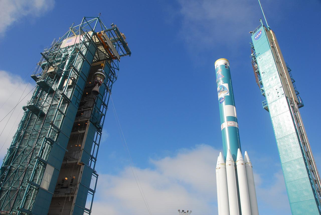 VANDENBERG AIR FORCE BASE, Calif. -- At Vandenberg Air Force Base in California, the AJ10 engine for the second stage of the United Launch Alliance Delta II rocket is hoisted high at NASA’s Space Launch Complex-2 service tower. The second stage of the rocket, with several solid rocket motors attached, sits on the launch pad. The Delta II will carry NASA's National Polar-orbiting Operational Environmental Satellite System Preparatory Project (NPP) satellite into space.    NPP represents a critical first step in building the next-generation of Earth-observing satellites. NPP will carry the first of the new sensors developed for this satellite fleet, now known as the Joint Polar Satellite System (JPSS) to be launched in 2016. NPP is the bridge between NASA's Earth Observing System (EOS) satellites and the forthcoming series of JPSS satellites. The mission will test key technologies and instruments for the JPSS missions. NPP is targeted to launch Oct. 25. For more information, visit http://www.nasa.gov/NPP. Photo credit: NASA/VAFB