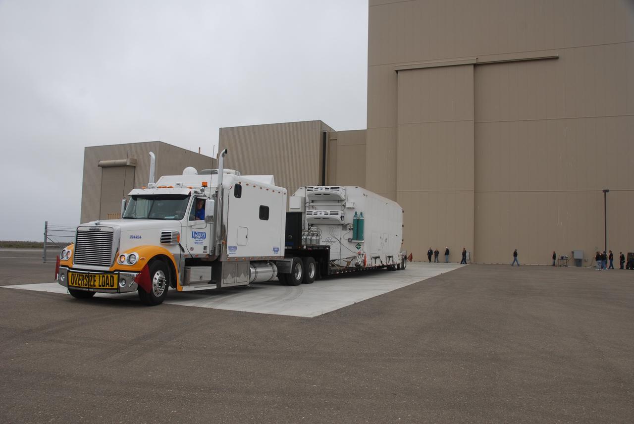 VANDENBERG AIR FORCE BASE, Calif. -- The environmentally controlled transportation container holding NASA's National Polar-orbiting Operational Environmental Satellite System Preparatory Project (NPP) satellite arrives outside the Astrotech payload processing facility on Vandenberg Air Force Base in California.    NPP represents a critical first step in building the next-generation of Earth-observing satellites. NPP will carry the first of the new sensors developed for this satellite fleet, now known as the Joint Polar Satellite System (JPSS), to be launched in 2016. NPP is the bridge between NASA's Earth Observing System (EOS) satellites and the forthcoming series of JPSS satellites. The mission will test key technologies and instruments for the JPSS missions. NPP is targeted to launch Oct. 25 from Space Launch Complex-2 aboard a United Launch Alliance Delta II rocket. For more information, visit http://www.nasa.gov/NPP.    Photo credit: USAF 30th Space Communications Squadron/Doug Gruben, VAFB