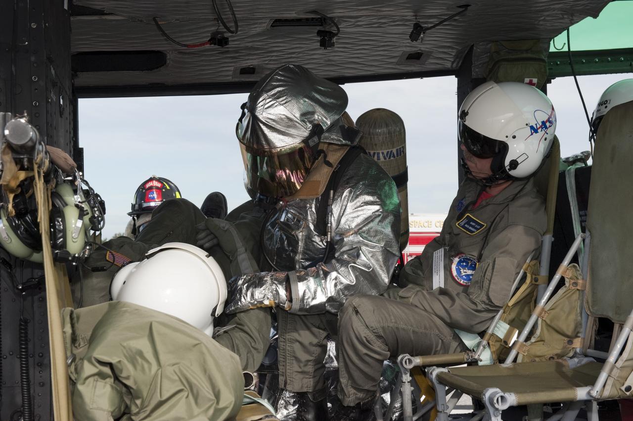 CAPE CANAVERAL, Fla. -- NASA Fire Rescue personnel assist volunteers portraying injured Huey II helicopter crew members participating in the aviation safety exercise during Emergency Response Safety Training at the Shuttle Landing Facility, Runway 33, at NASA’s Kennedy Space Center in Florida.    The simulated helicopter mishap exercise was conducted to evaluate emergency response and mishap investigations of aircraft at Kennedy. Participants included Air Rescue Fire Fighters, Flight Operations, Disaster Preparedness, Security, and Safety. NASA mandates simulated aviation safety training take place every two years. Photo credit: NASA/Kim Shiflett