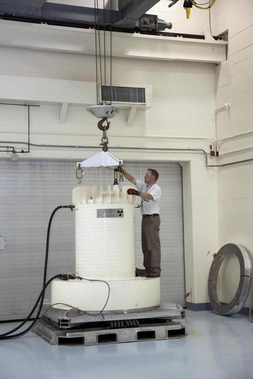 CAPE CANAVERAL, Fla. -- In the high bay of the RTG storage facility at NASA's Kennedy Space Center in Florida, a Department of Energy contractor employee attaches a crane to the shipping cask enclosing the multi-mission radioisotope thermoelectric generator (MMRTG) for NASA's Mars Science Laboratory mission during preparations to lift it from its transportation pallet. The MMRTG will generate the power needed for the mission from the natural decay of plutonium-238, a non-weapons-grade form of the radioisotope. Heat given off by this natural decay will provide constant power through the day and night during all seasons. Waste heat from the MMRTG will be circulated throughout the rover system to keep instruments, computers, mechanical devices and communications systems within their operating temperature ranges. MSL's components include a compact car-sized rover, Curiosity, which has 10 science instruments designed to search for evidence on whether Mars has had environments favorable to microbial life, including chemical ingredients for life. The unique rover will use a laser to look inside rocks and release its gasses so that the rover’s spectrometer can analyze and send the data back to Earth. Launch of MSL aboard a United Launch Alliance Atlas V rocket is scheduled for Nov. 25 from Space Launch Complex 41 on Cape Canaveral Air Force Station in Florida. For more information, visit http://www.nasa.gov/msl. Photo credit: NASA/Frankie Martin