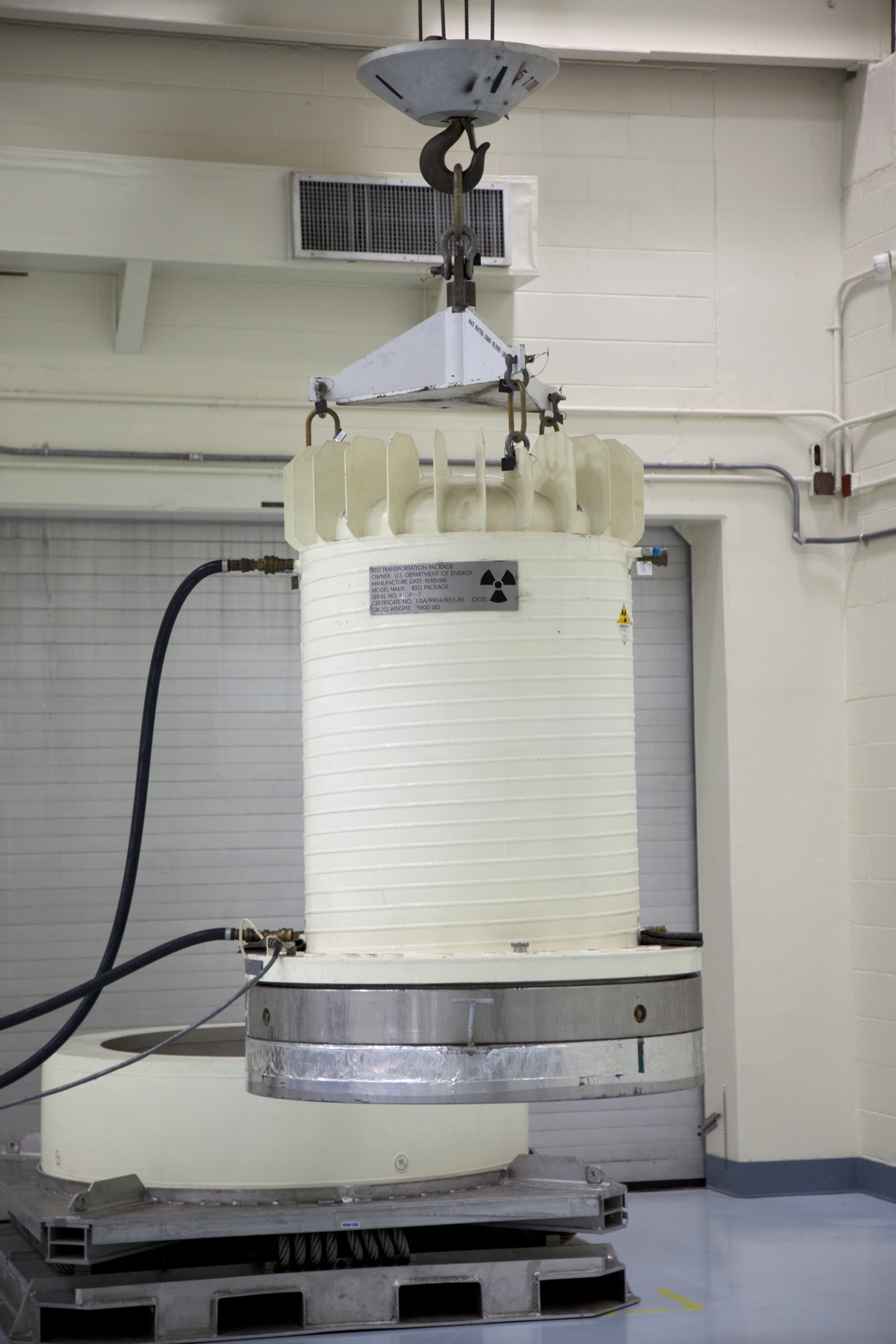 CAPE CANAVERAL, Fla. -- In the high bay of the RTG storage facility at NASA's Kennedy Space Center in Florida, a crane lifts the shipping cask enclosing the multi-mission radioisotope thermoelectric generator (MMRTG) for NASA's Mars Science Laboratory mission from its transportation pallet.    The MMRTG will generate the power needed for the mission from the natural decay of plutonium-238, a non-weapons-grade form of the radioisotope. Heat given off by this natural decay will provide constant power through the day and night during all seasons.     Waste heat from the MMRTG will be circulated throughout the rover system to keep instruments, computers, mechanical devices and communications systems within their operating temperature ranges.     MSL's components include a compact car-sized rover, Curiosity, which has 10 science instruments designed to search for evidence on whether Mars has had environments favorable to microbial life, including chemical ingredients for life.  The unique rover will use a laser to look inside rocks and release its gasses so that the rover’s spectrometer can analyze and send the data back to Earth. Launch of MSL aboard a United Launch Alliance Atlas V rocket is scheduled for Nov. 25 from Space Launch Complex 41 on Cape Canaveral Air Force Station in Florida. For more information, visit http://www.nasa.gov/msl. Photo credit: NASA/Frankie Martin