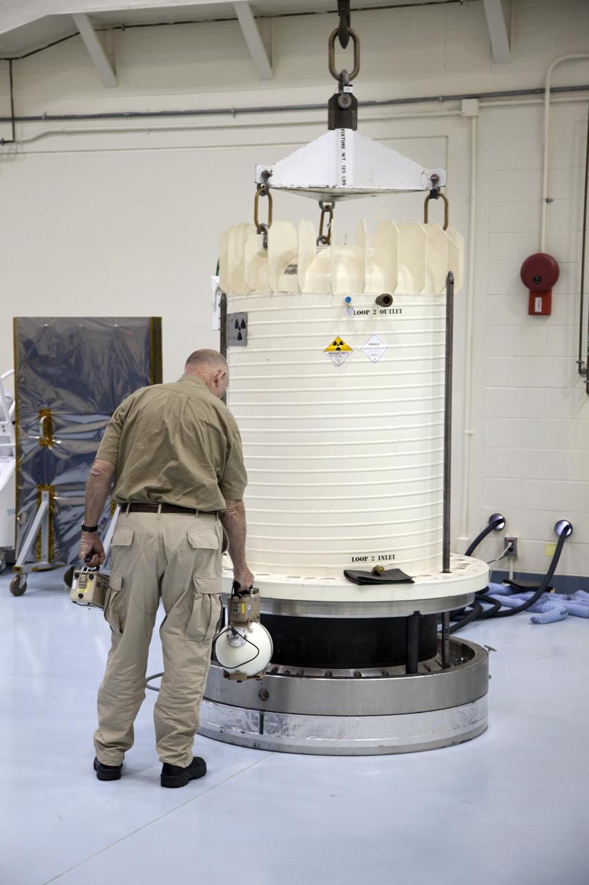 CAPE CANAVERAL, Fla. -- In the high bay of the RTG storage facility at NASA's Kennedy Space Center in Florida, Innovative Health Applications employee David Lake measures the level of radioactivity emitted from the multi-mission radioisotope thermoelectric generator (MMRTG) for NASA's Mars Science Laboratory mission as the external protective layer of the shipping cask is removed. The MMRTG will generate the power needed for the mission from the natural decay of plutonium-238, a non-weapons-grade form of the radioisotope. Heat given off by this natural decay will provide constant power through the day and night during all seasons. Waste heat from the MMRTG will be circulated throughout the rover system to keep instruments, computers, mechanical devices and communications systems within their operating temperature ranges. MSL's components include a compact car-sized rover, Curiosity, which has 10 science instruments designed to search for evidence on whether Mars has had environments favorable to microbial life, including chemical ingredients for life. The unique rover will use a laser to look inside rocks and release its gasses so that the rover’s spectrometer can analyze and send the data back to Earth. Launch of MSL aboard a United Launch Alliance Atlas V rocket is scheduled for Nov. 25 from Space Launch Complex 41 on Cape Canaveral Air Force Station in Florida. For more information, visit http://www.nasa.gov/msl. Photo credit: NASA/Frankie Martin