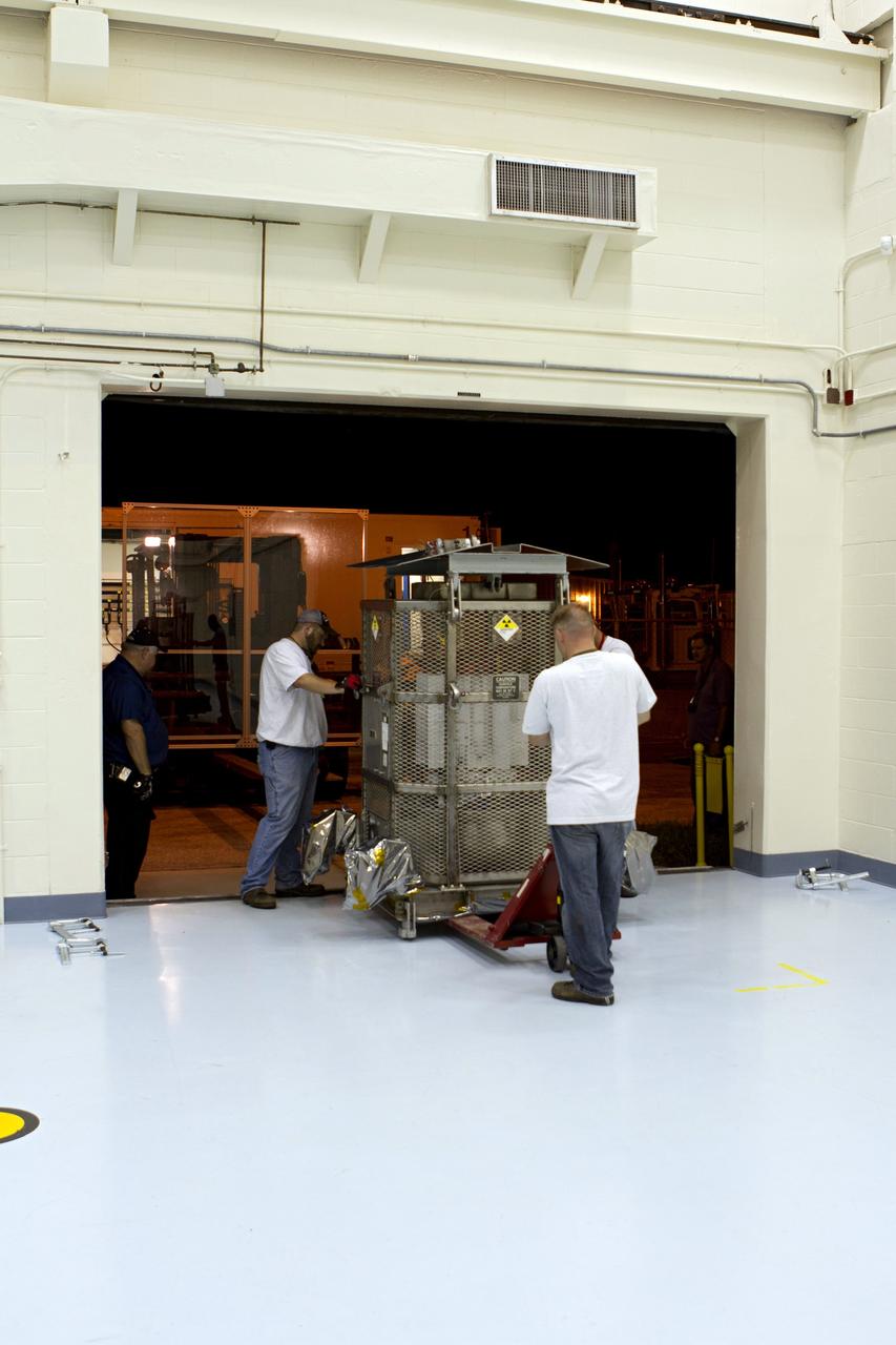 CAPE CANAVERAL, Fla. -- Department of Energy contractor employees roll the multi-mission radioisotope thermoelectric generator (MMRTG) for NASA's Mars Science Laboratory (MSL) mission, enclosed in a protective mesh container known as the "gorilla cage," out of the high bay of the RTG storage facility at NASA's Kennedy Space Center in Florida for its move to the Payload Hazardous Servicing Facility (PHSF). The cage protects the MMRTG and allows any excess heat generated to dissipate into the air. In the PHSF, the MMRTG temporarily will be installed on the MSL rover, Curiosity, for a fit check but will be installed on the rover for launch at the pad. The MMRTG will generate the power needed for the mission from the natural decay of plutonium-238, a non-weapons-grade form of the radioisotope. Heat given off by this natural decay will provide constant power through the day and night during all seasons. Curiosity, MSL's car-sized rover, has 10 science instruments designed to search for signs of life, including methane, and help determine if the gas is from a biological or geological source. Waste heat from the MMRTG will be circulated throughout the rover system to keep instruments, computers, mechanical devices and communications systems within their operating temperature ranges. Launch of MSL aboard a United Launch Alliance Atlas V rocket is planned for Nov. 25 from Space Launch Complex 41 on Cape Canaveral Air Force Station. For more information, visit http://www.nasa.gov/msl. Photo credit: NASA/Cory Huston